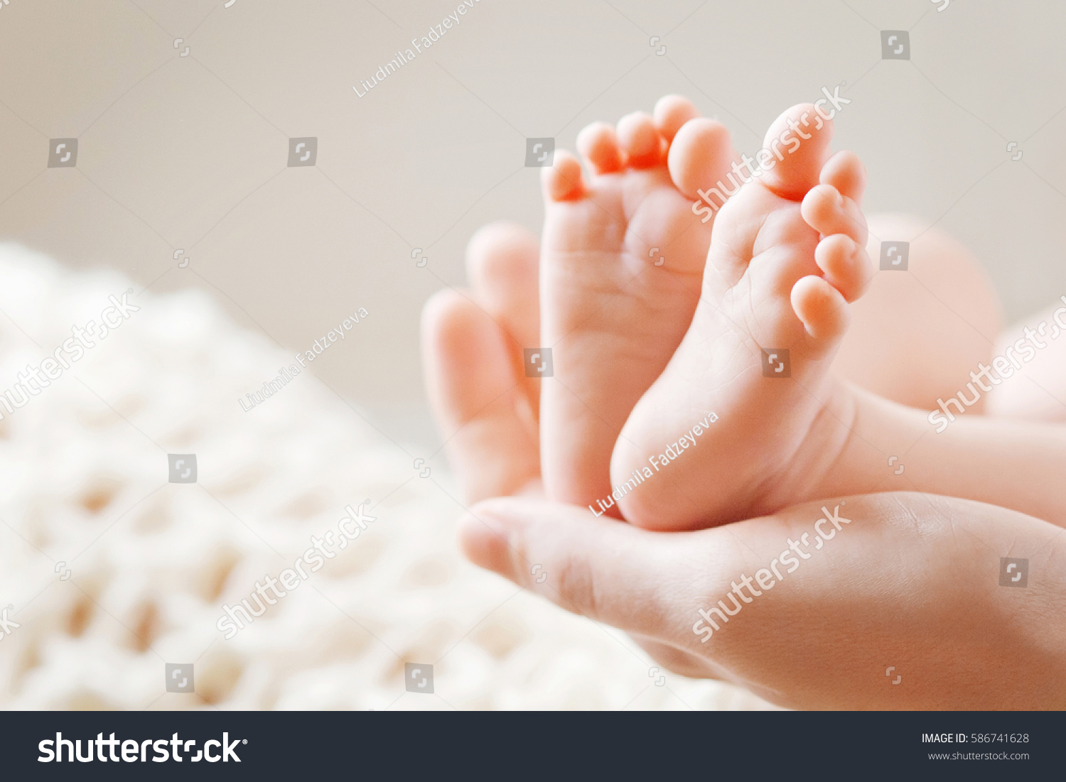 Baby feet in mother hands. Mom and her Child. Happy Family concept. Beautiful conceptual image of Maternity #586741628