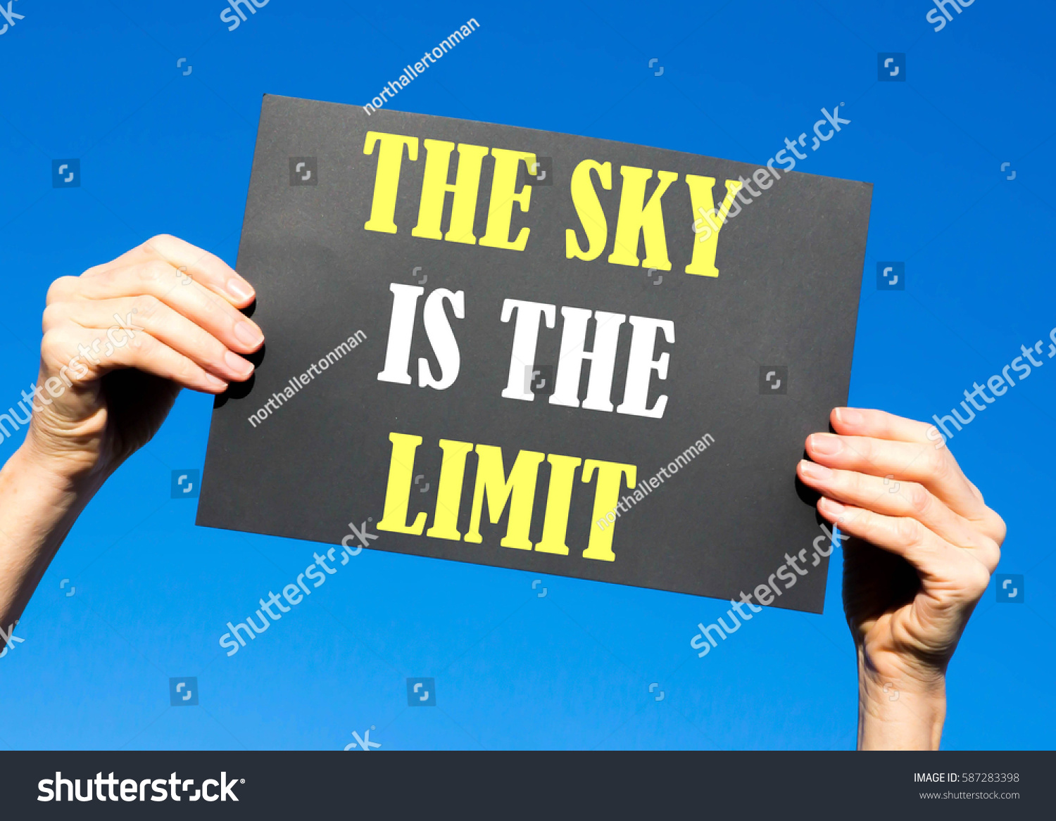 Black card placard with the concept of The Sky Is The Limit against a clear blue sky background #587283398