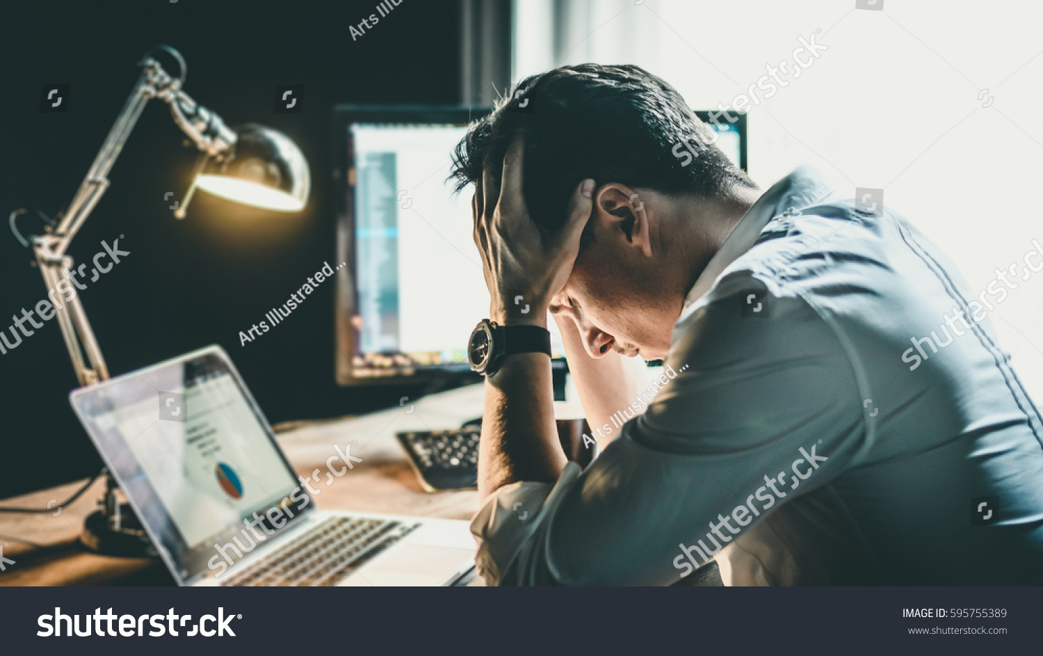 Tired and worried business man at workplace in office holding his head on hands after late night work, concept #595755389