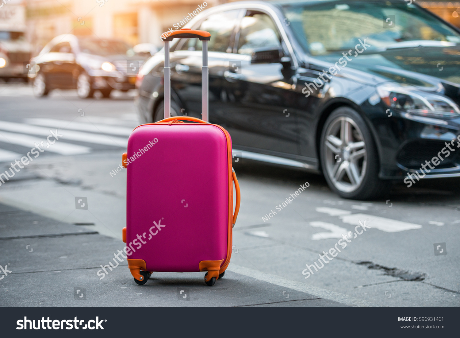 Luggage bag on the city street ready to pick by airport transfer taxi car. #596931461