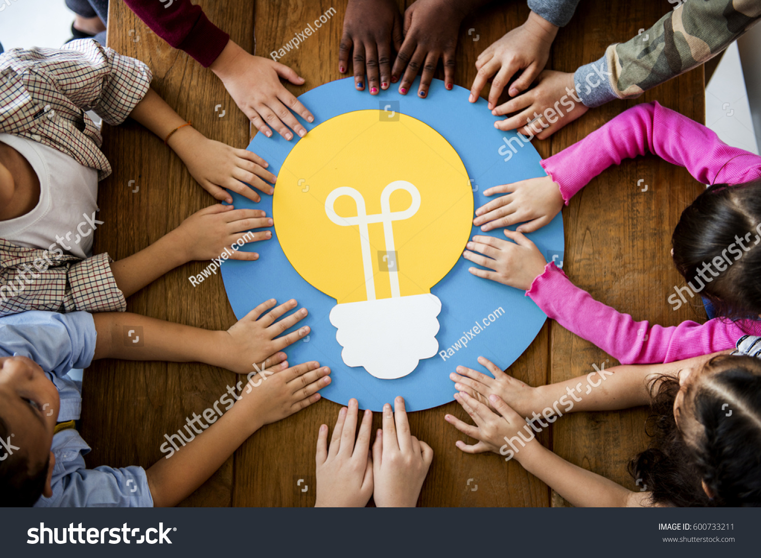 Group of children branstorming and sharing ideas with light bulb #600733211