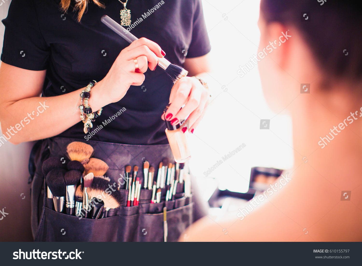 Makeup artist doing makeup for girl indoor #610155797