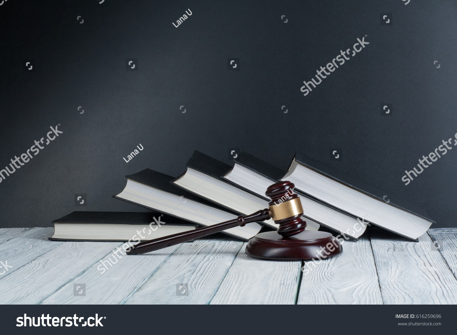 Law concept - Open law book with a wooden judges gavel on table in a courtroom or law enforcement office on blue background. Copy space for text #616259696