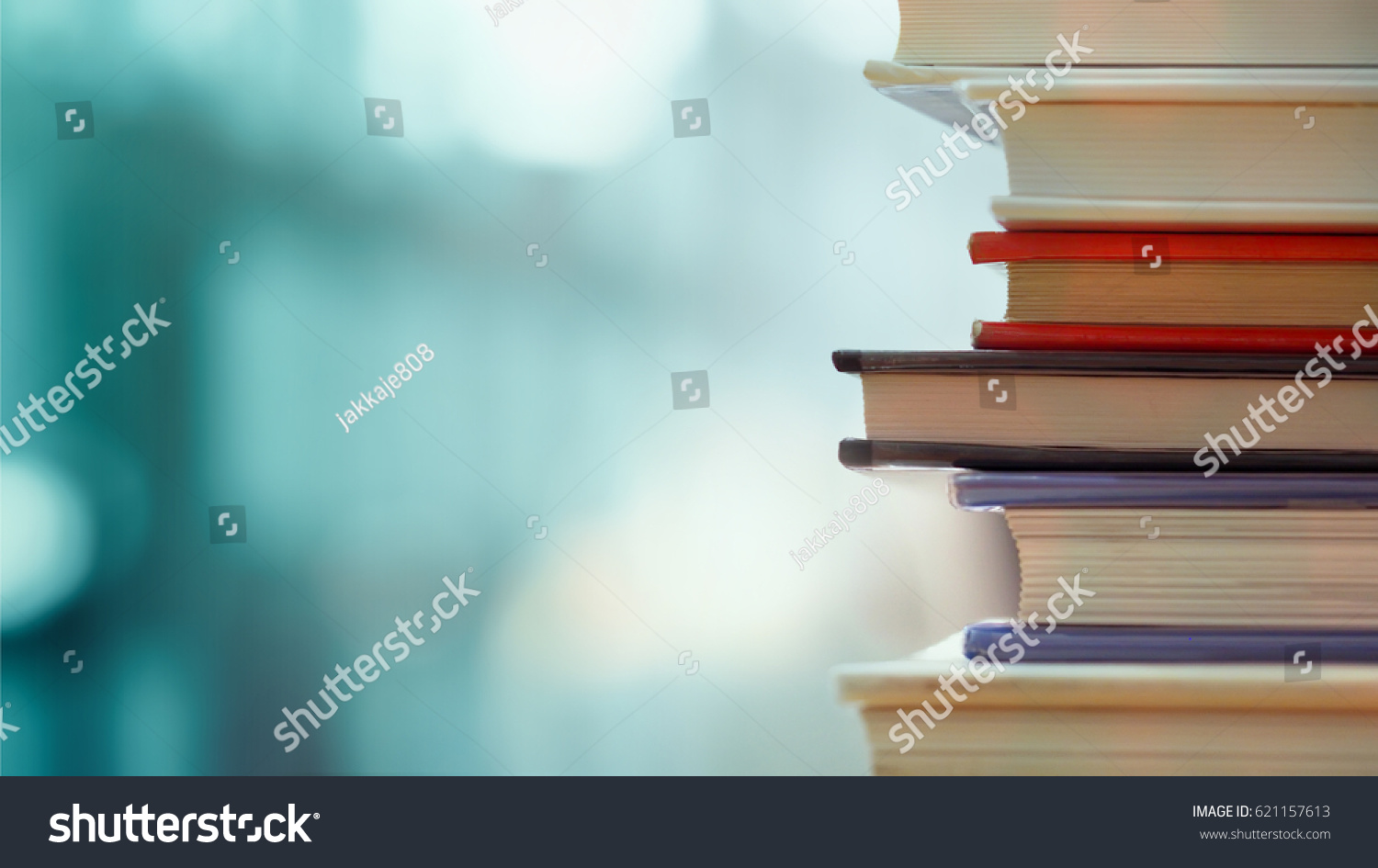 Book stack in the library room and blurred bookshelf for business and education background, back to school concept #621157613