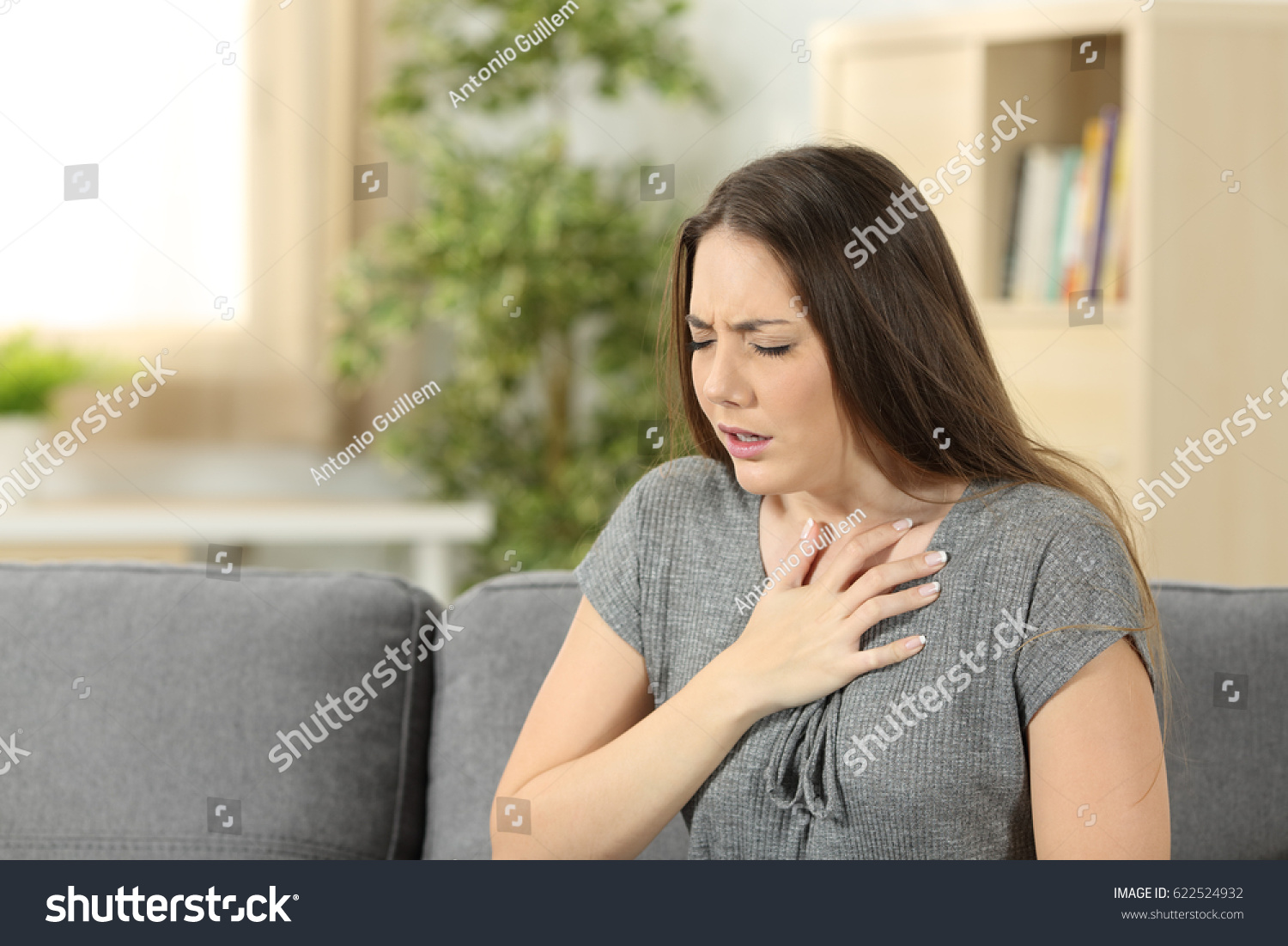 Woman suffering respiration problems sitting on a couch in the living room at home #622524932