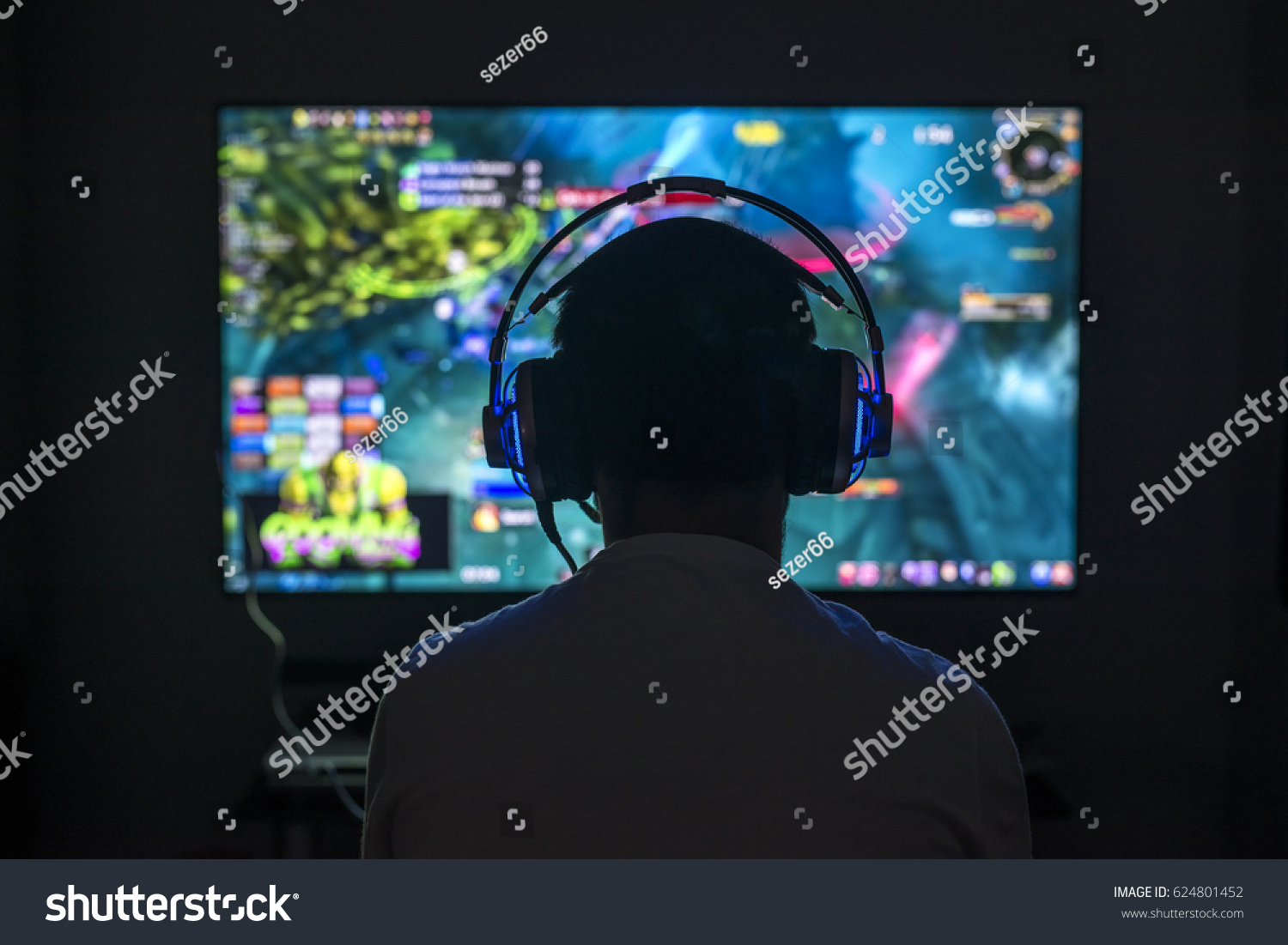 Young gamer playing video game wearing headphone.
 #624801452