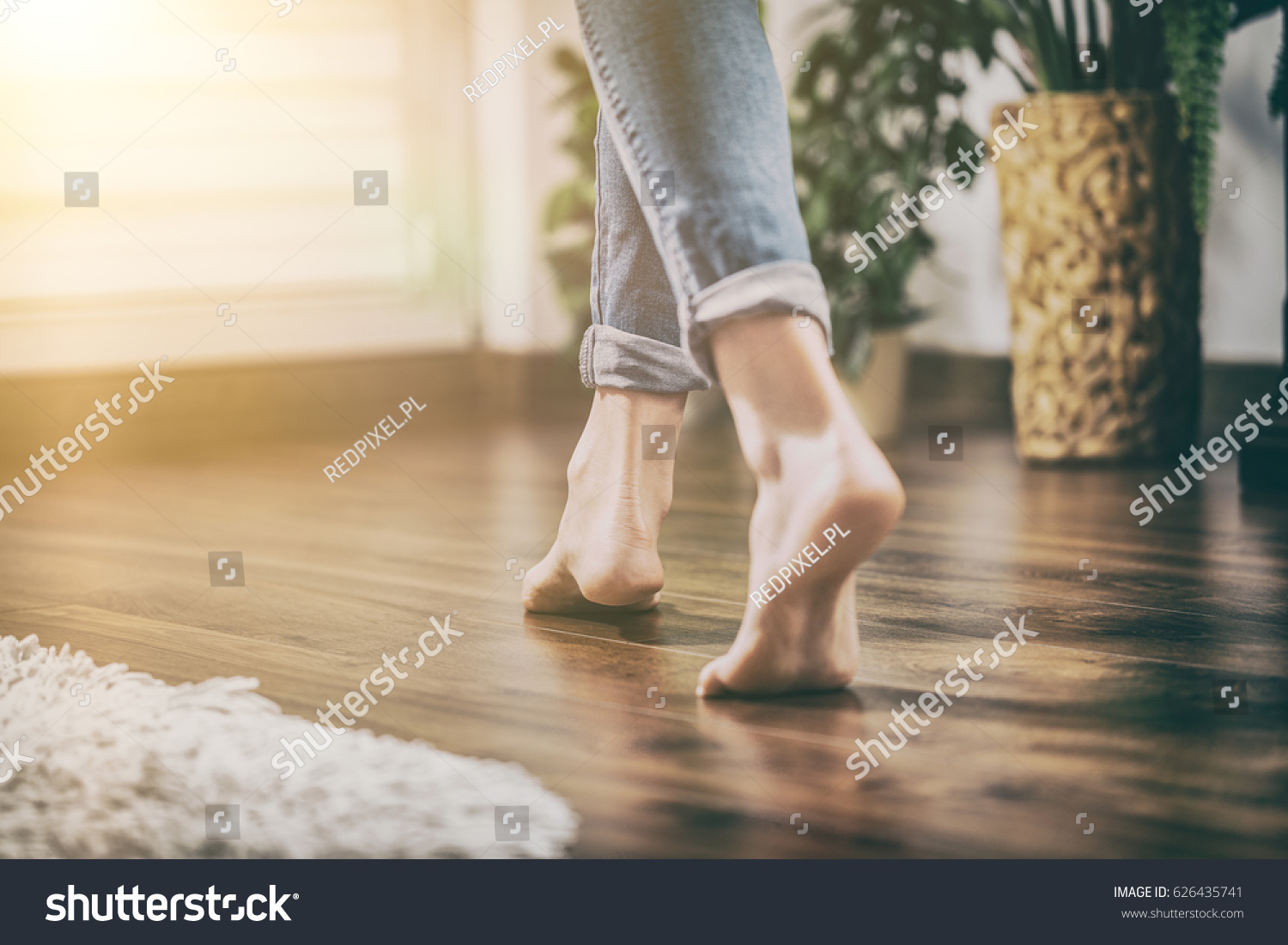 Floor heating. Young woman walking in the house on the warm floor. Gently walked the wooden panels. #626435741