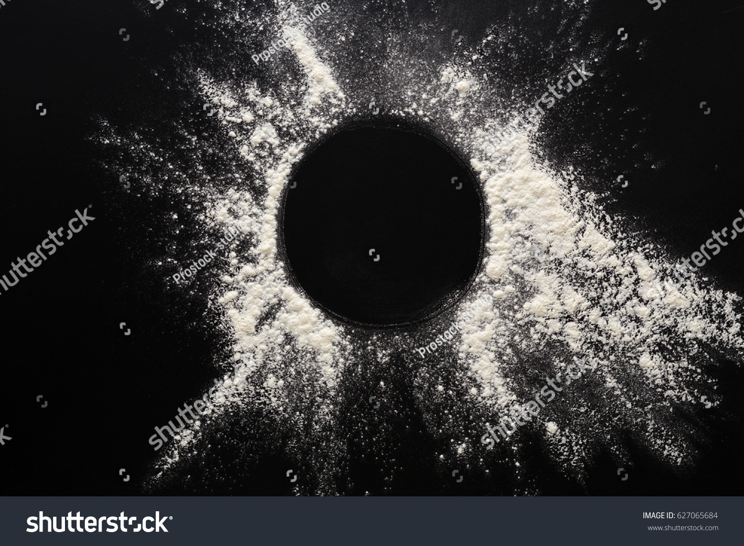 Abstract background. Sprinkled wheat flour circle, round spot on black. Top view on blackboard. Baking concept, cooking dough or pastry. #627065684