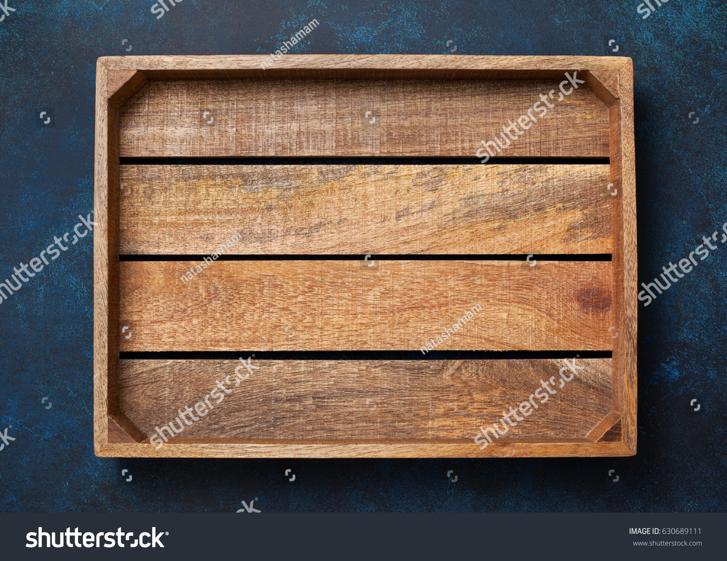 Empty wooden box on blue background. View from above. Copy space #630689111