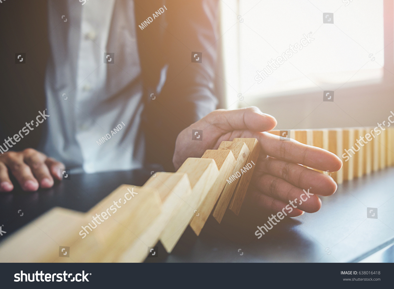 Problem Solving,Close up view on hand of business woman stopping falling blocks on table for concept about taking responsibility. #638016418