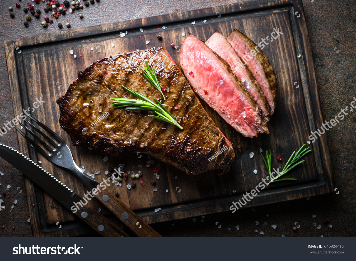 Fresh grilled meat. Grilled beef steak medium rare on wooden cutting board. Top view. #640904416