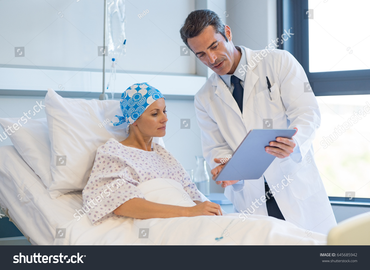 Doctor telling to patient woman the results of her medical tests. Doctor showing medical records to cancer patient in hospital ward. Senior doctor explaint the side effects of the intervention. #645685942