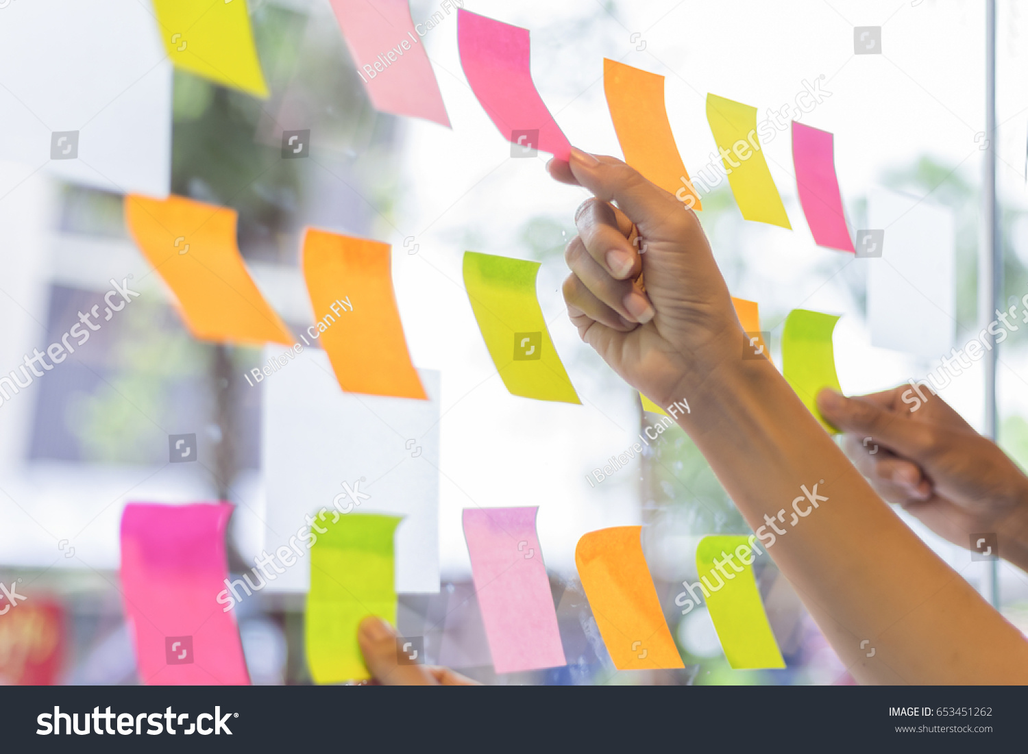 business people post it notes in glass wall at meeting room #653451262
