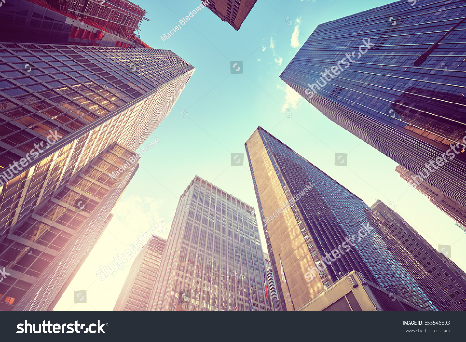 Vintage stylized photo of Manhattan skyscrapers at sunset, looking up perspective, New York City, USA.  #655546693