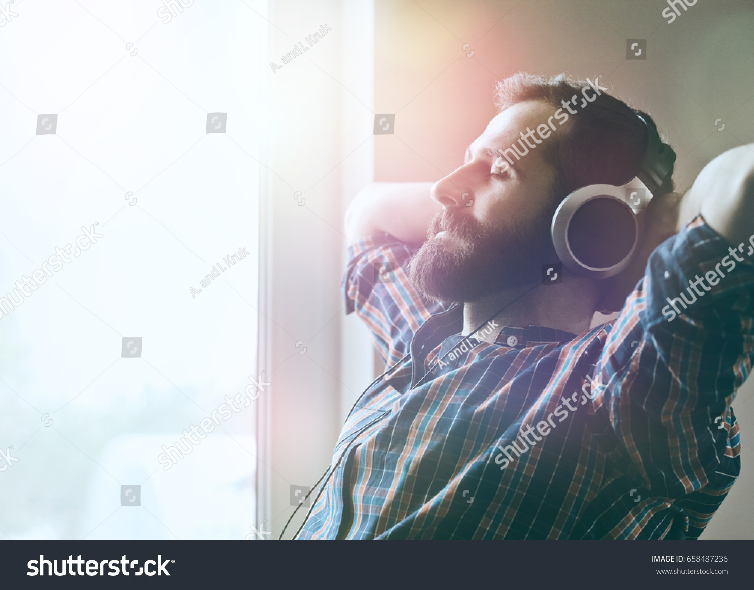 handsome bearded man  in headphones listening to music #658487236