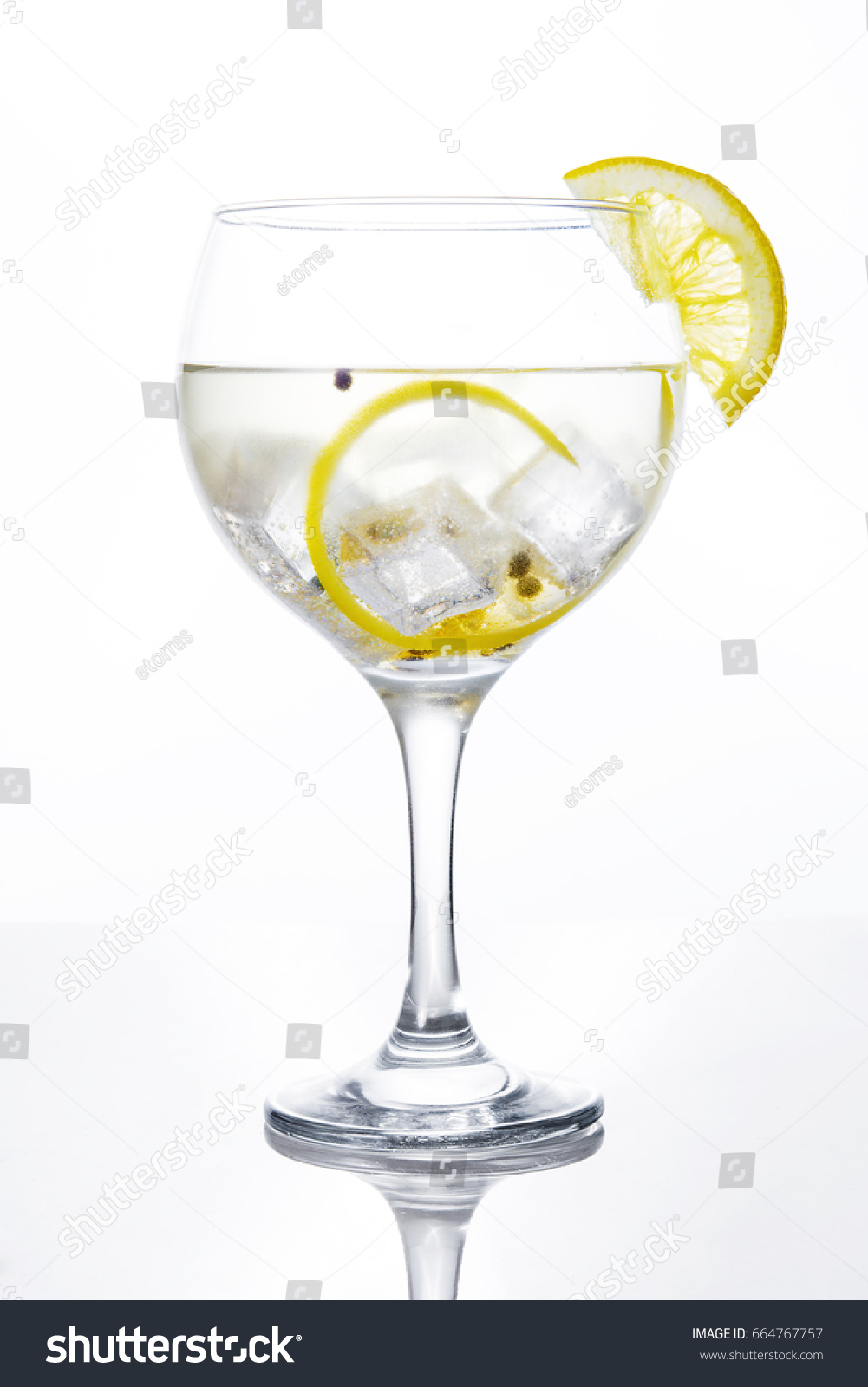 Glass of gin tonic with lemon on white background #664767757