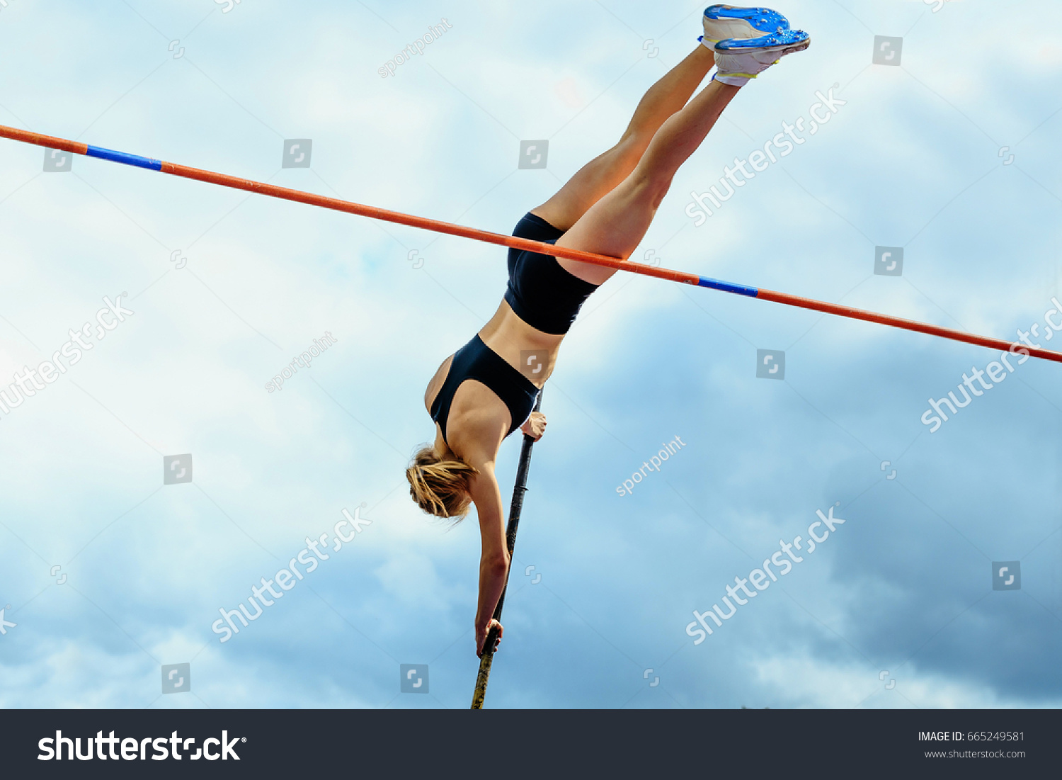 competition pole vault jumper female on blue sky background #665249581
