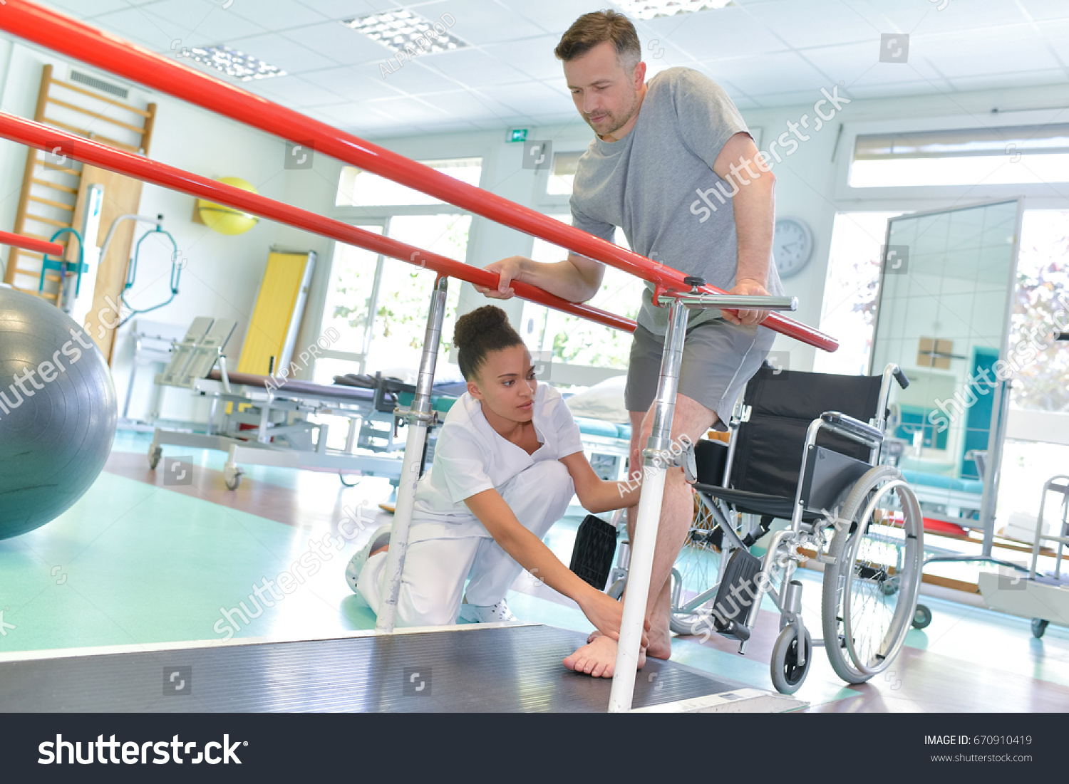 Occupational therapist helping patient to walk #670910419
