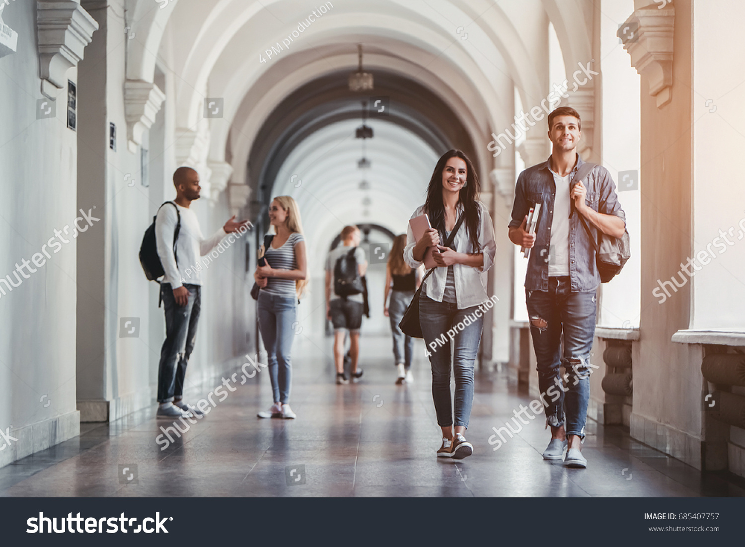 Multiracial students are walking in university hall during break and communicating. #685407757