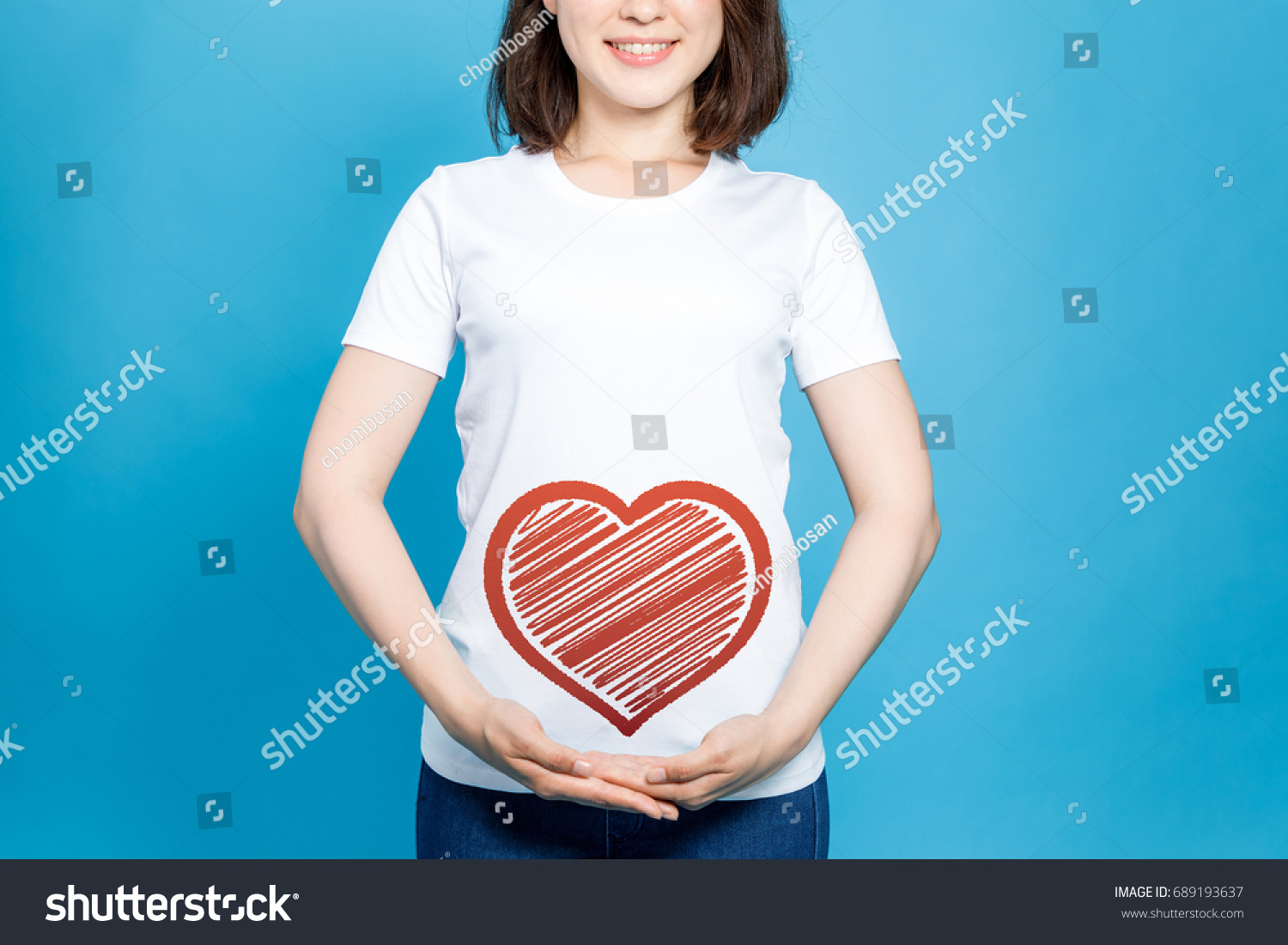 young woman holding a heart symbol. #689193637