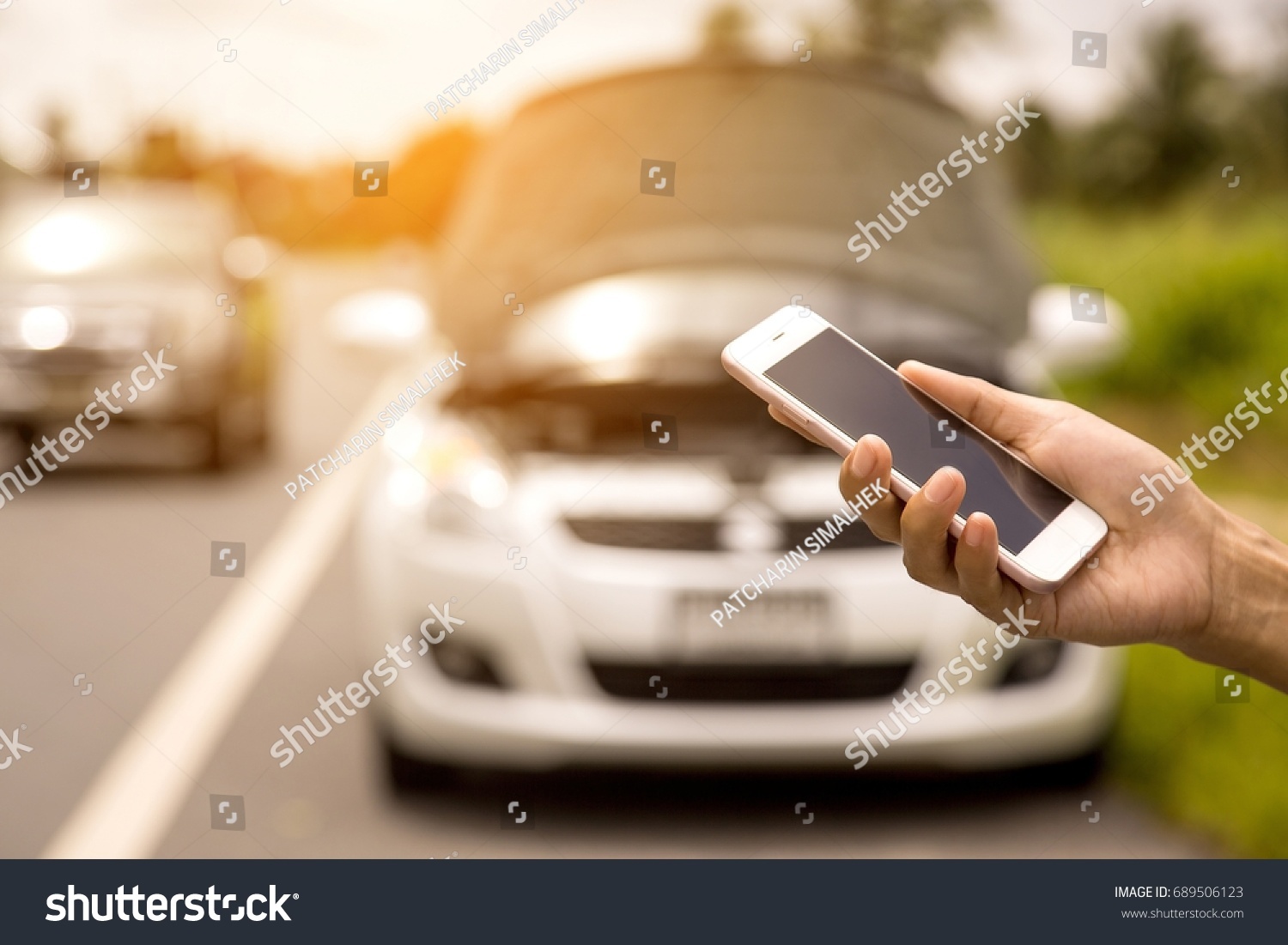 Using a mobile phone call a car mechanic because car was broken. #689506123