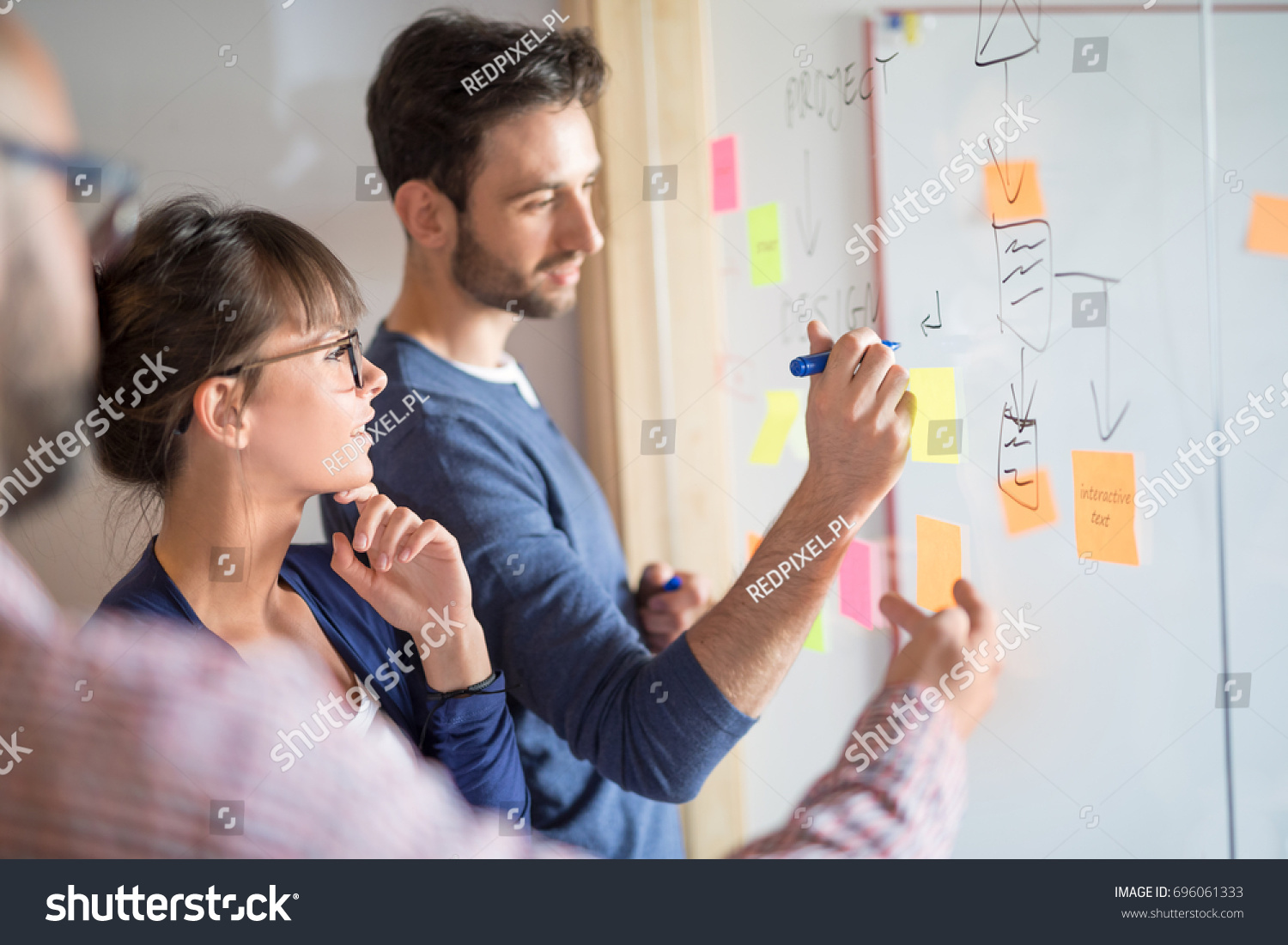 Business people meeting at office and use post it notes to share idea. Brainstorming concept. Sticky note on glass wall. #696061333