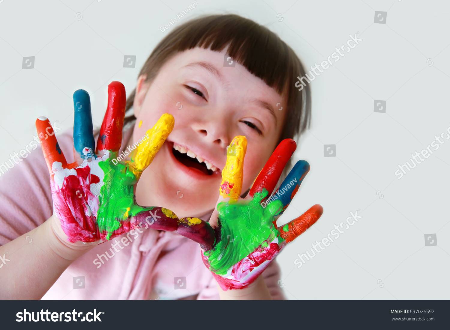 Cute little down syndrome girl with painted hands. #697026592