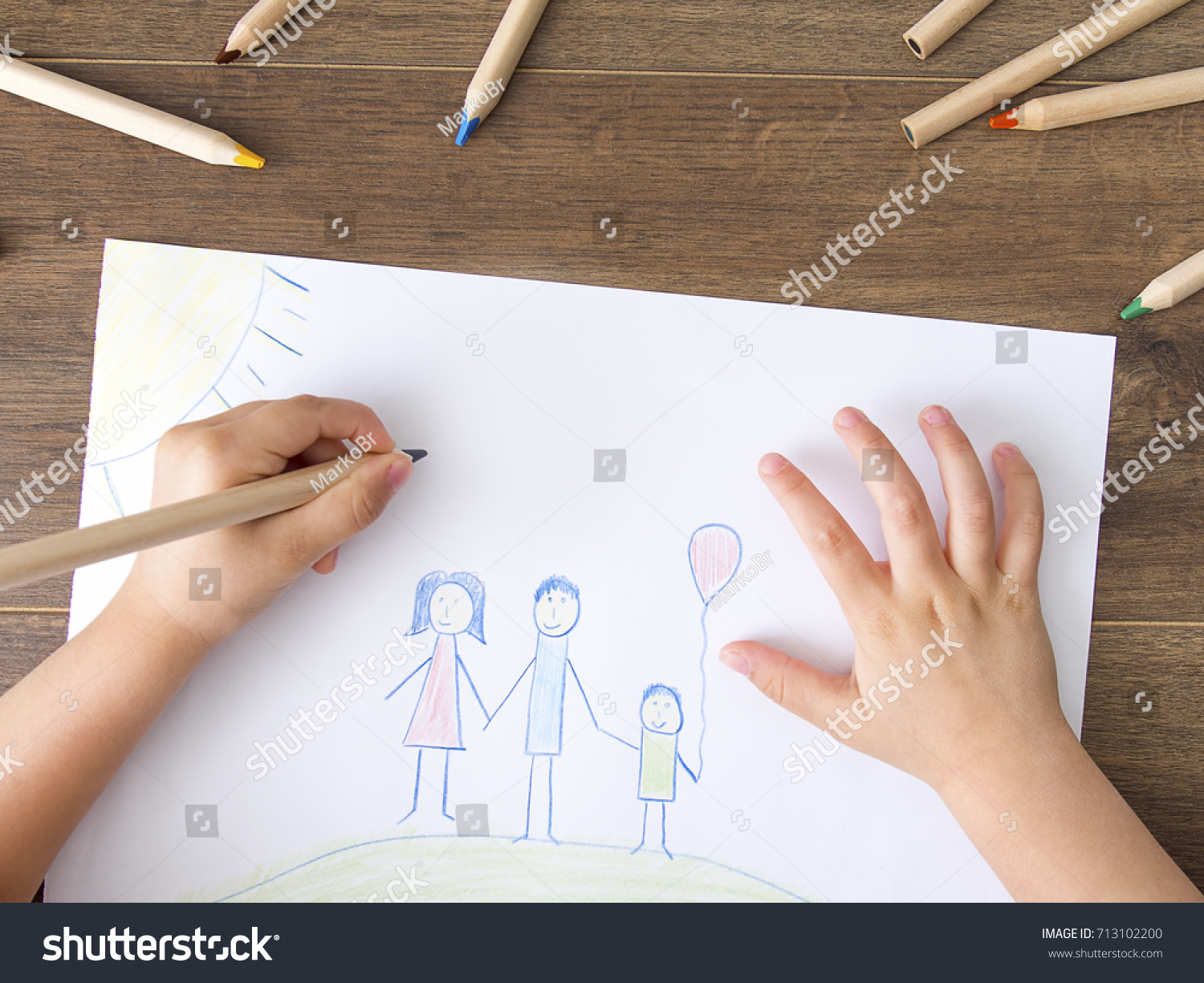 Child drawing happy family on paper. Top View #713102200