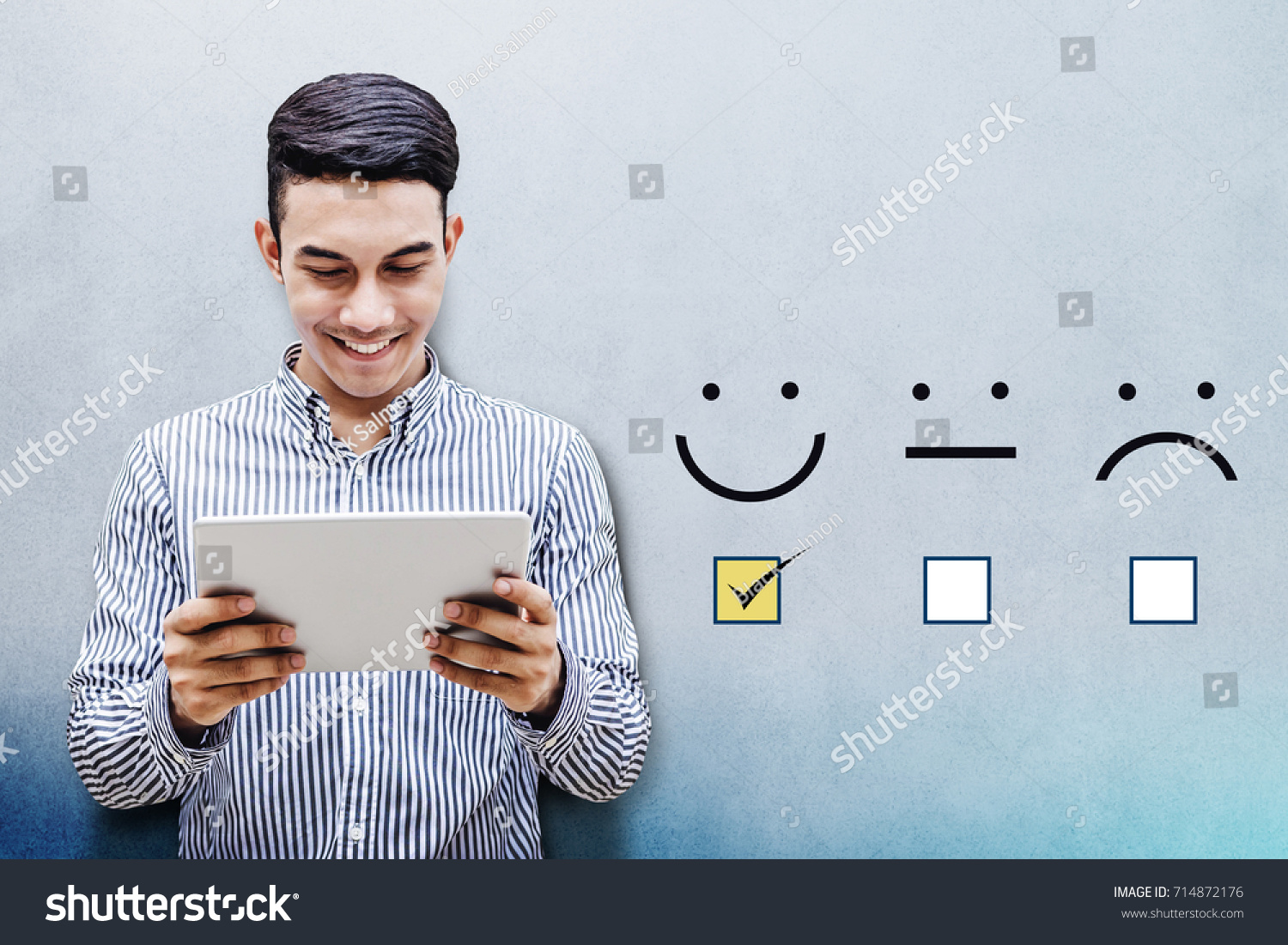 Customer Experience Concept, Happy Businessman holding digital Tablet with a checked box on Excellent Smiley Face Rating for a Satisfaction Survey #714872176