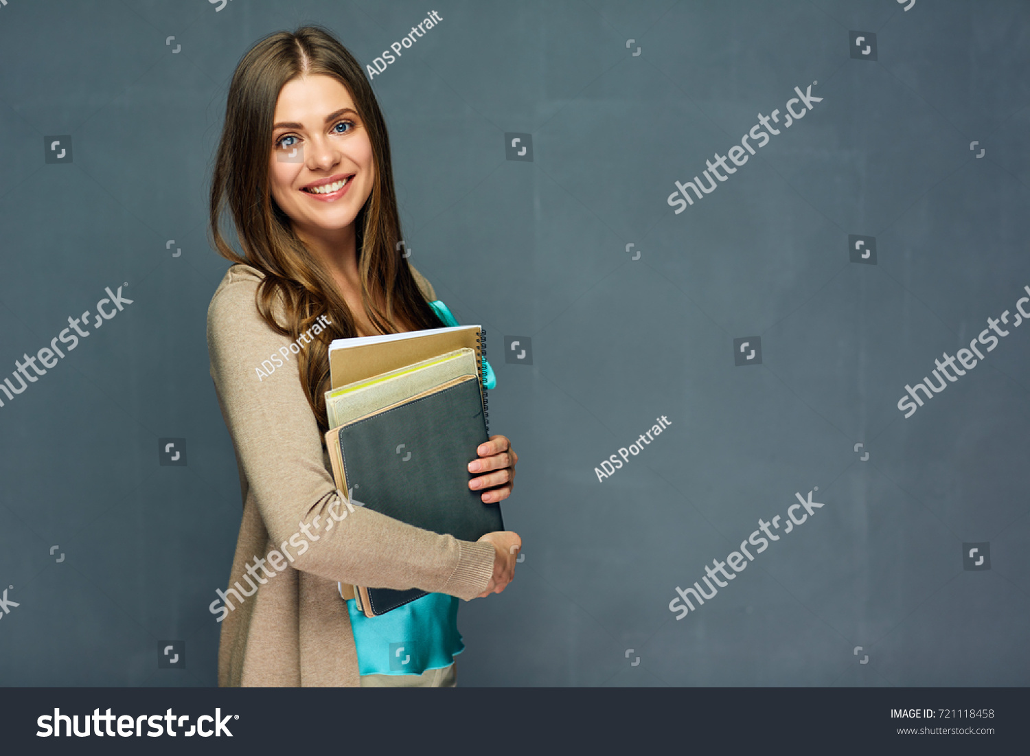 Smiling girl student or woman teacher portrait on gray wall. #721118458