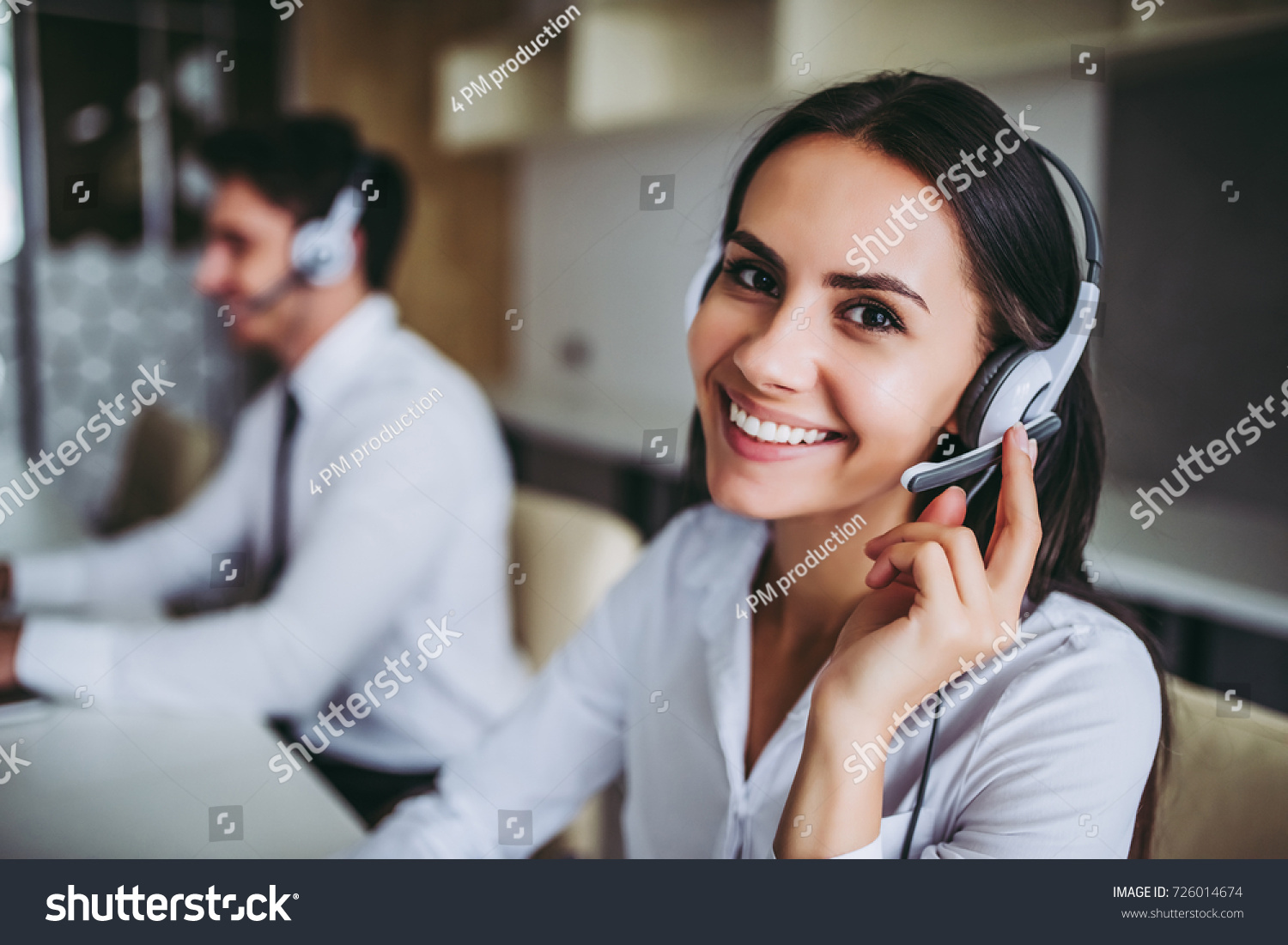 How can I help you? Beautiful call center workers in headphones are working at modern office. #726014674