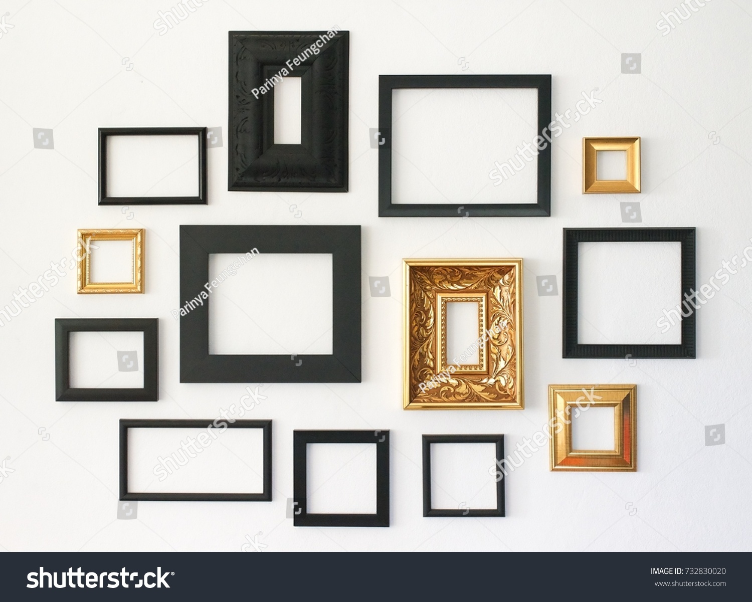Multiple many blank small picture frames on white wall #732830020