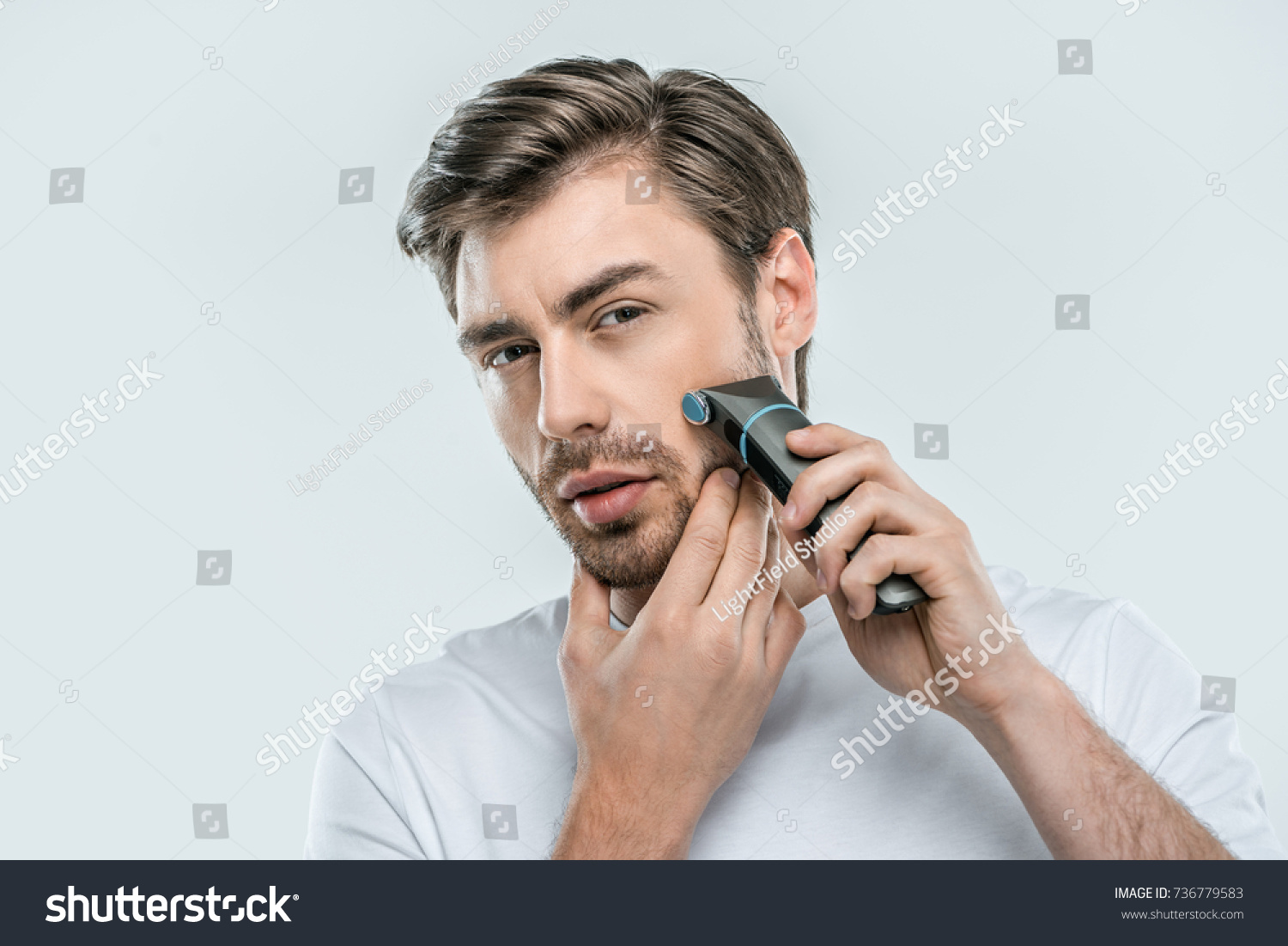 handsome man using electric razor, isolated on grey #736779583