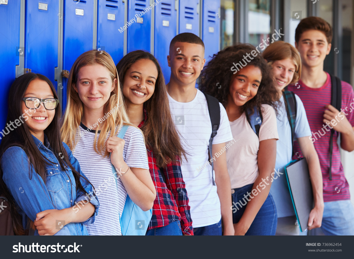 Teenage school kids smiling to camera in school corridor #736962454