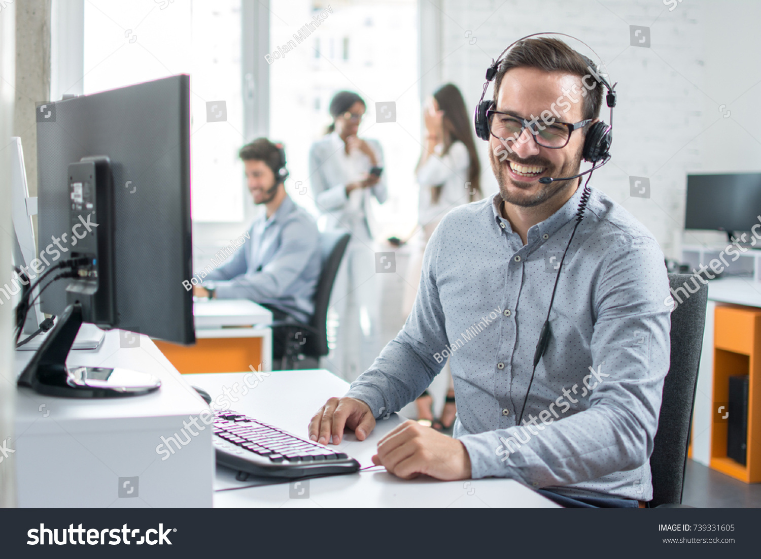 Happy young male customer support executive working in office. #739331605