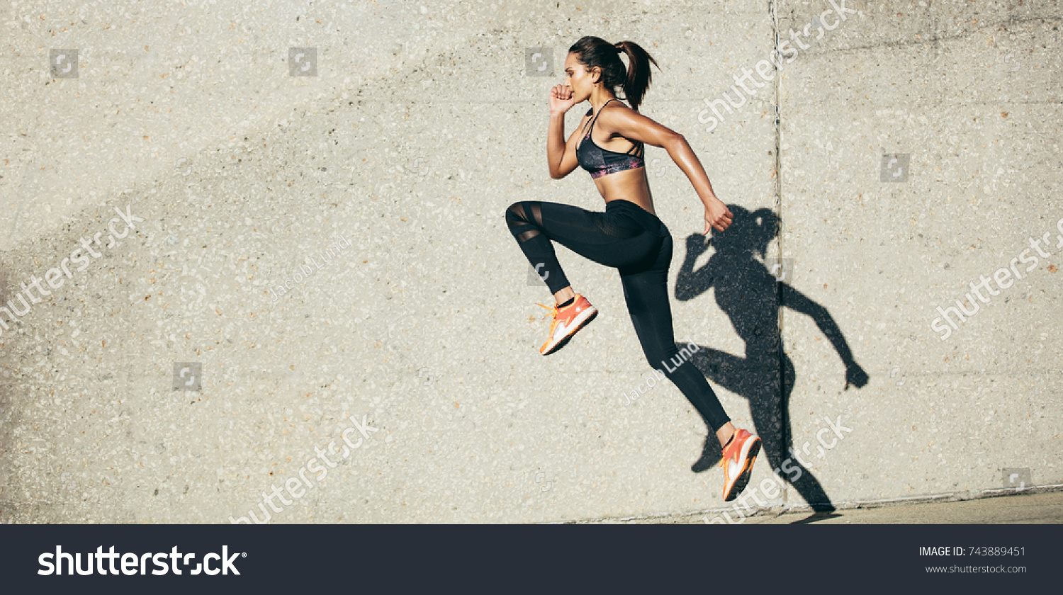 Fit woman exercising outdoors. Healthy young female athlete doing fitness workout. #743889451