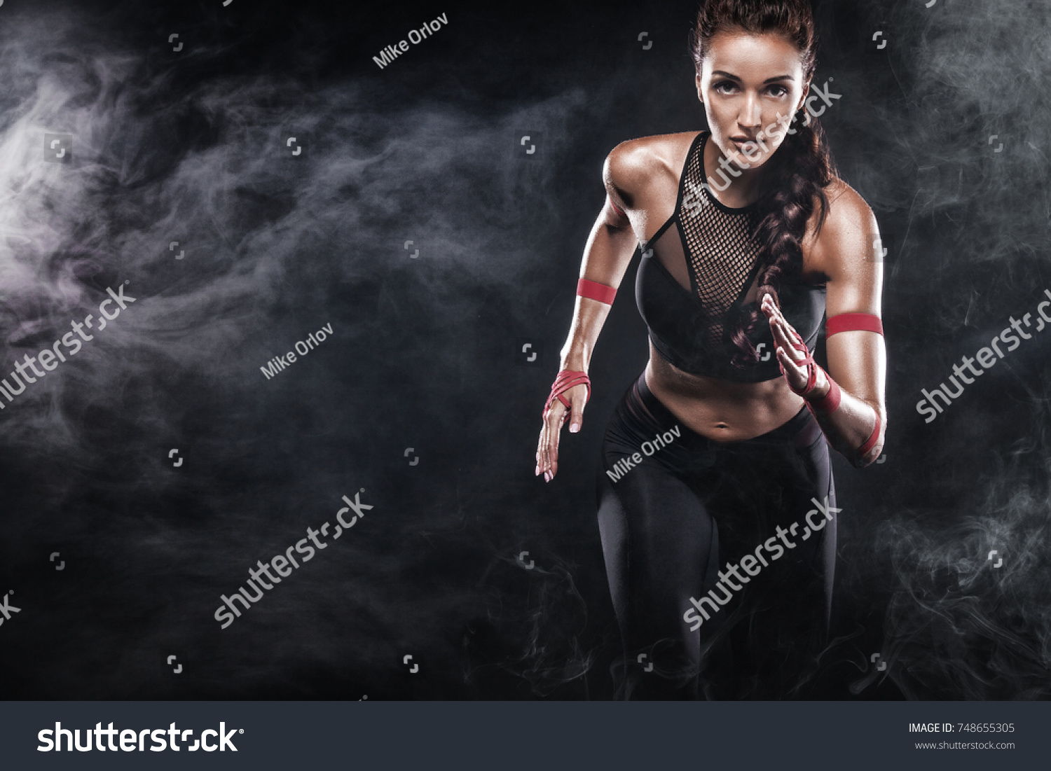 A strong athletic, woman sprinter, running on black background wearing in the sportswear, fitness and sport motivation. Runner concept with copy space. #748655305