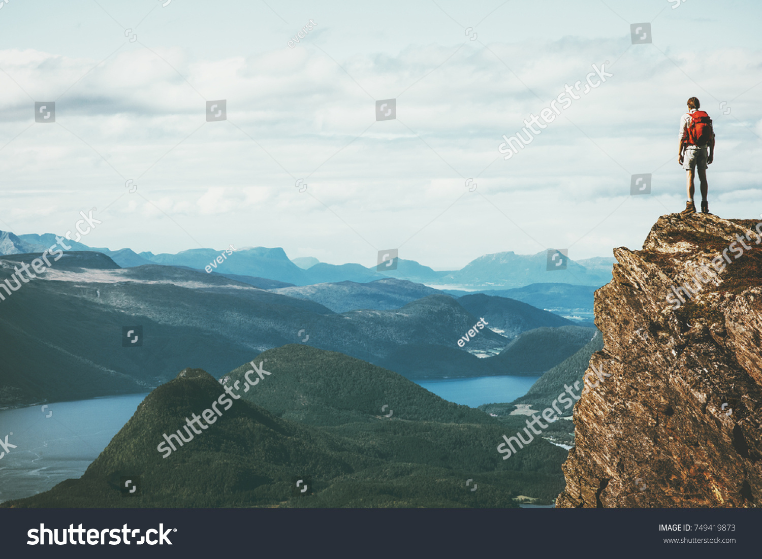 Life on the edge Traveler on cliff mountains over fjord enjoying Norway landscape Travel Lifestyle success motivation concept adventure active vacations outdoor #749419873