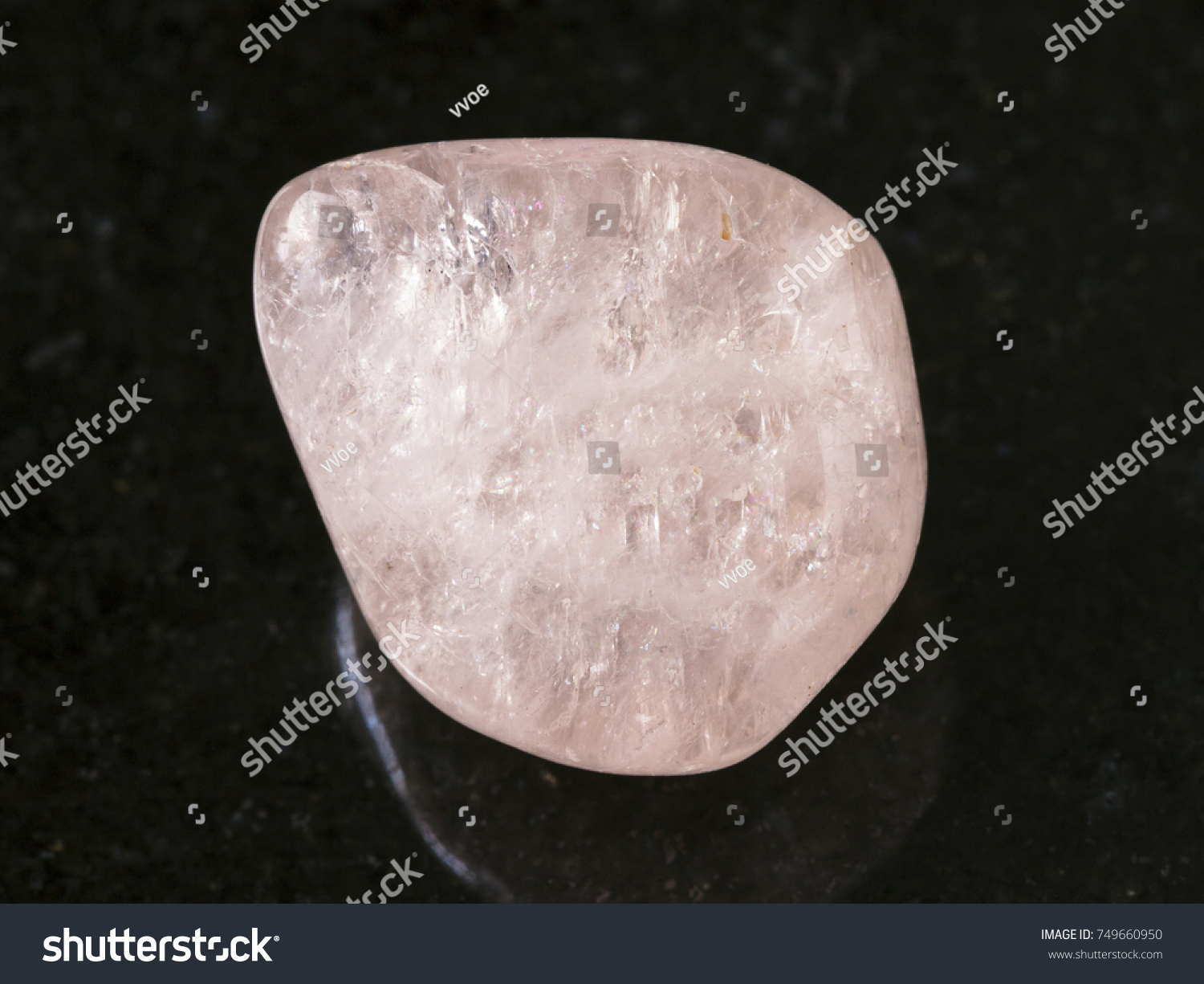 macro shooting of natural mineral rock specimen - tumbled morganite (pink beryl) gemstone on dark granite background from Ural Mountains, Russia #749660950