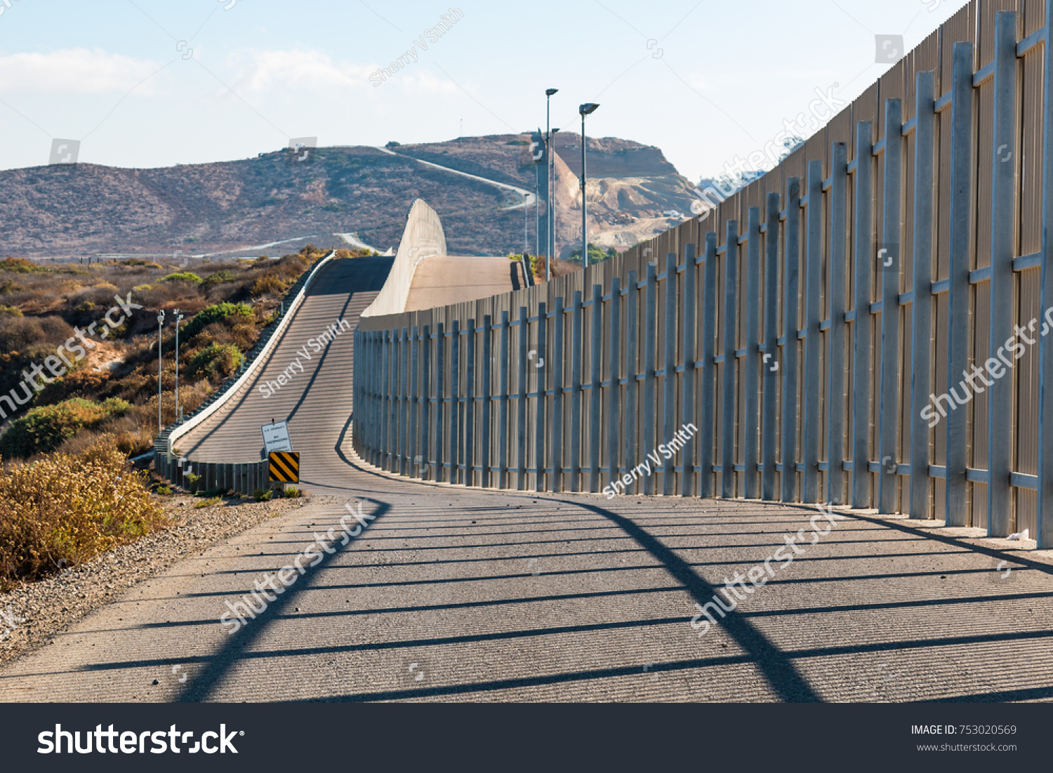 The international border wall between San Diego, California and Tijuana, Mexico, as it begins its journey from the Pacific coast and travels over nearby hills.   #753020569