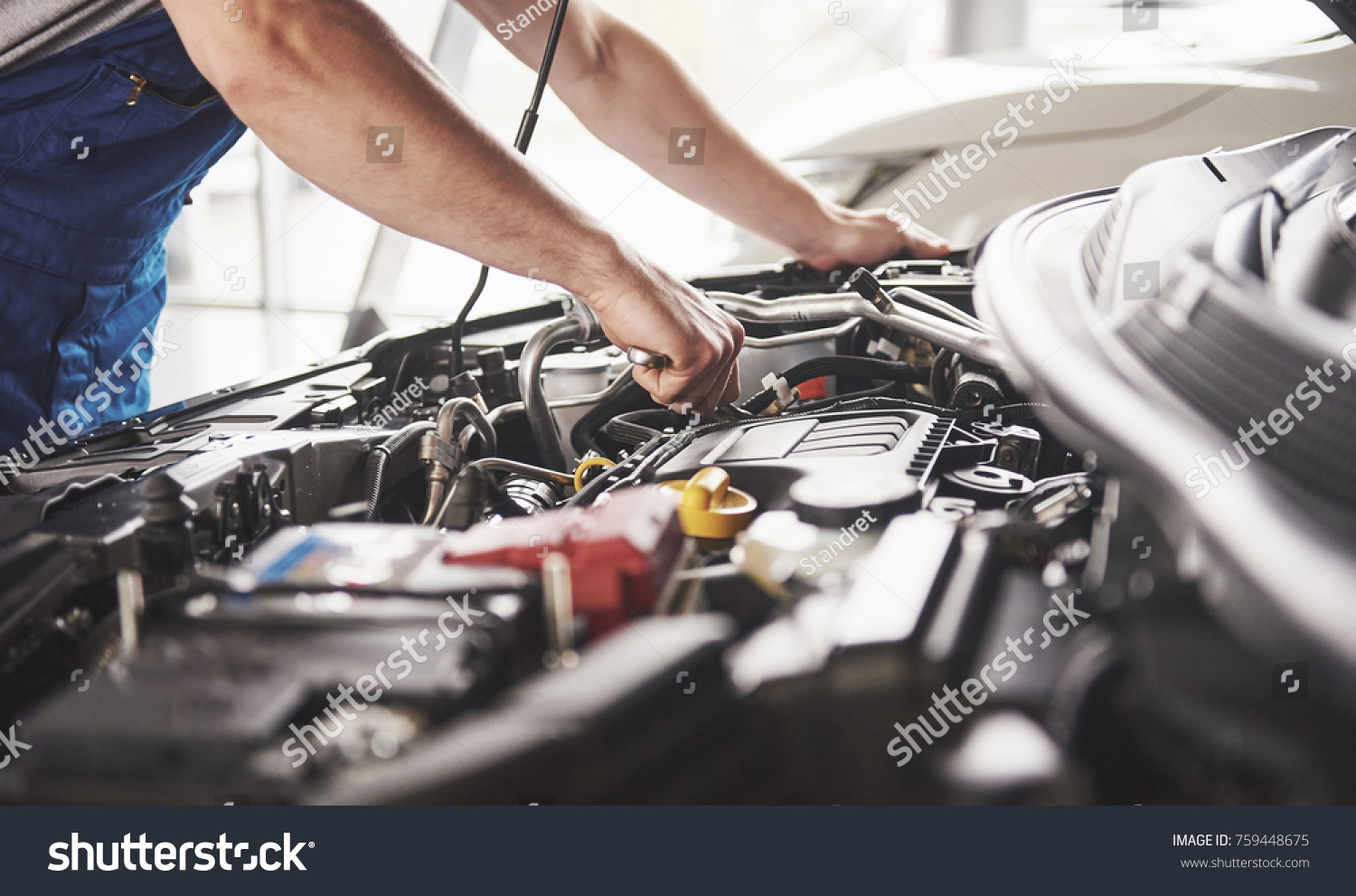 Auto mechanic working in garage. Repair service. #759448675