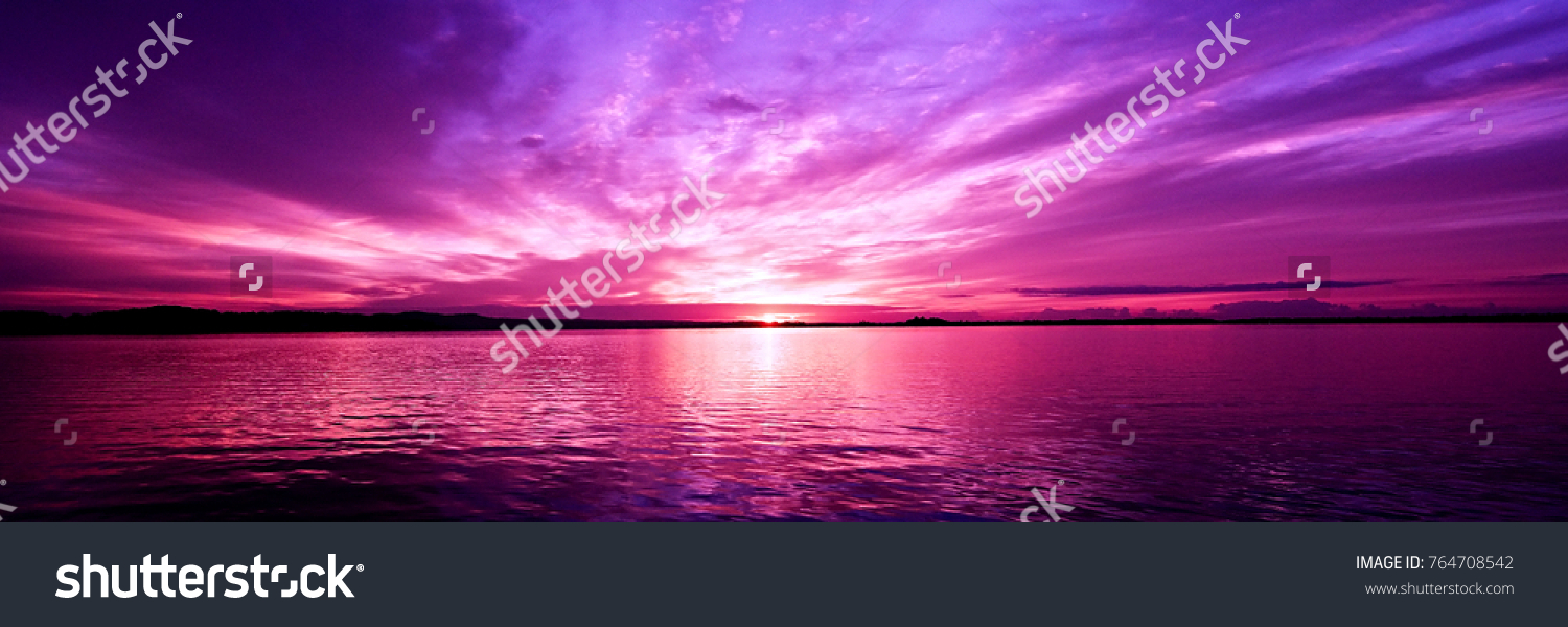 Delightful inspirational magenta coloured cloudy sea water tropical panoramic sunrise seascape featuring wispy cirrus clouds with sparkling ocean water reflections. Australia. #764708542
