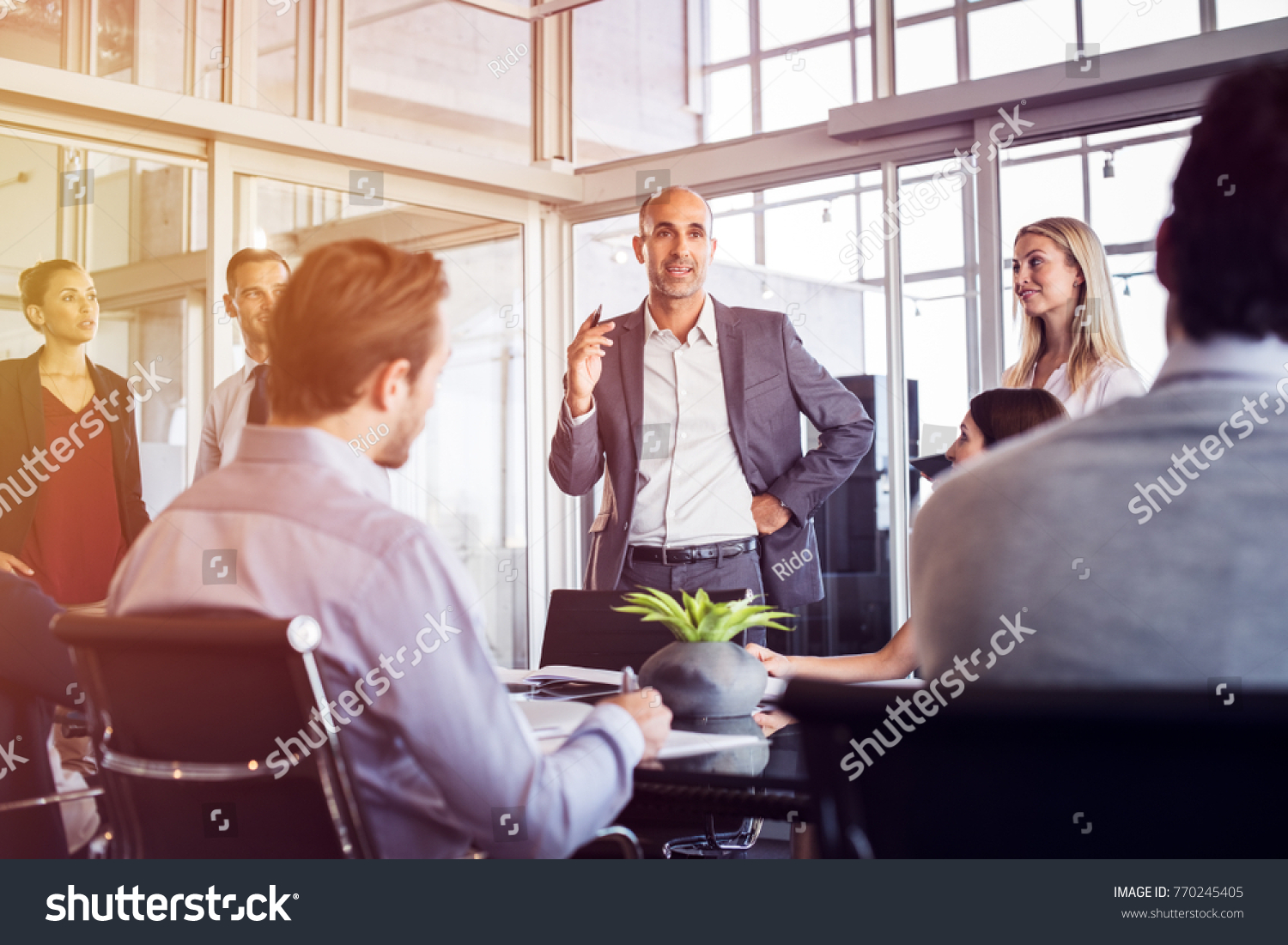 Senior man talking to employees in office meeting. Marketing team discussing new ideas with manager during a conference. Senior leadership training future businessmen and businesswomen. #770245405