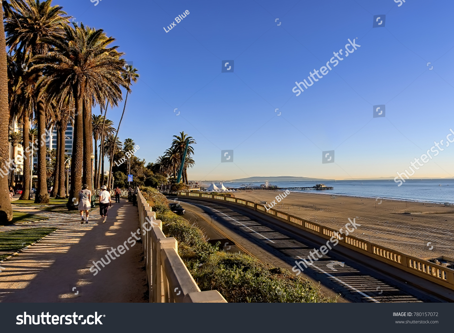 View of Santa Monica beach, California incline and Pacific Coast highway, and people walking in Palisades park. #780157072