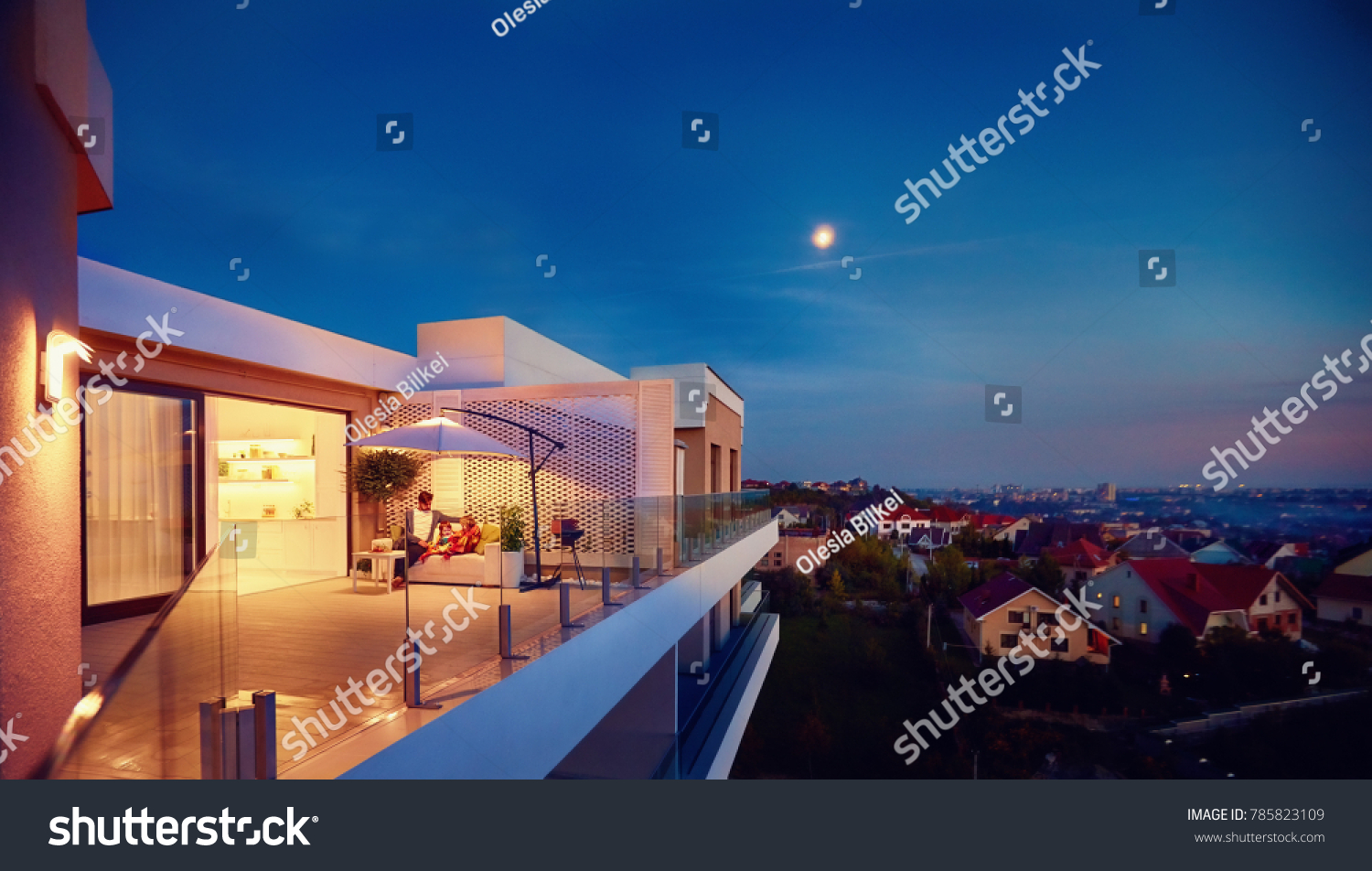 family relaxing on roof top patio with evening city view #785823109