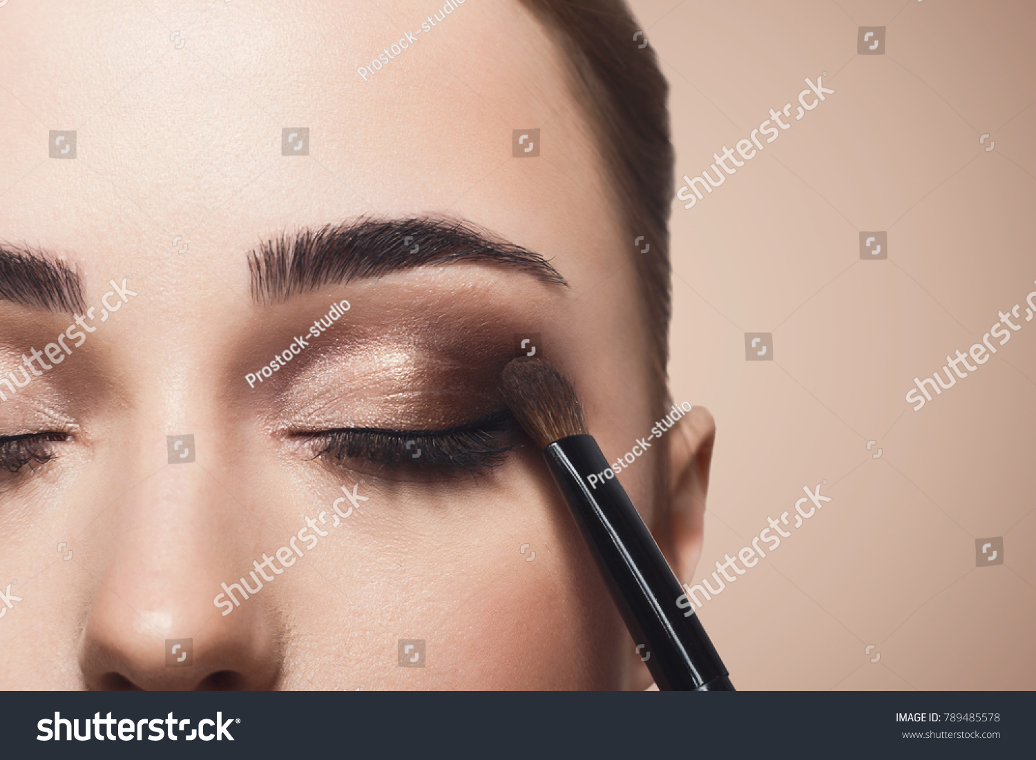 Eyeshadow applying, makeup for eyes closeup. Female model face with fashion make-up, beauty concept #789485578
