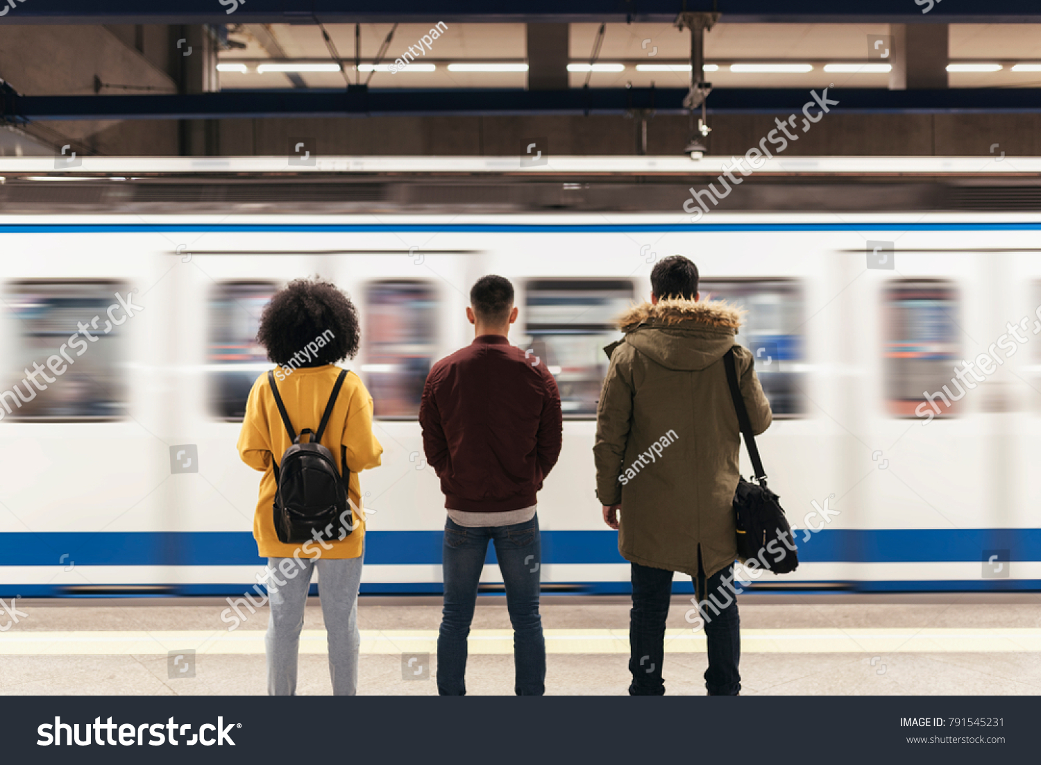 Group of friends waiting the train in the platform of subway station. Public transport concept. #791545231