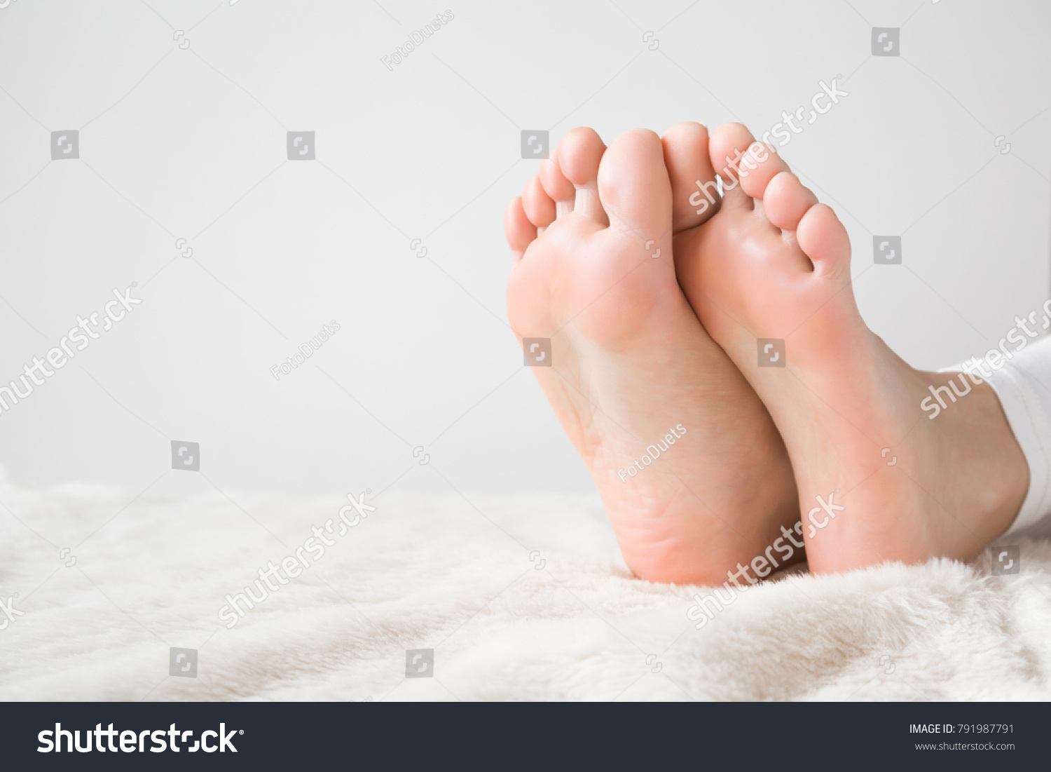 Elegant bare feet. Beautiful groomed woman's feet on the fluffy blanket. Cares about clean and soft legs skin. Lying and enjoying rest. #791987791