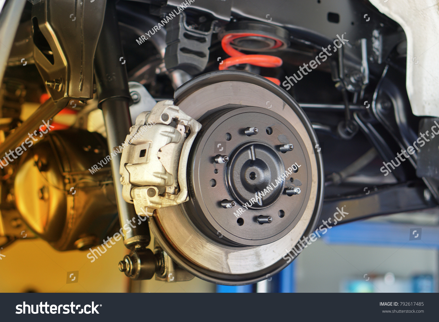 Disc brake of the vehicle for repair, in process of new tire replacement. Car brake repairing in garage.Close up. #792617485