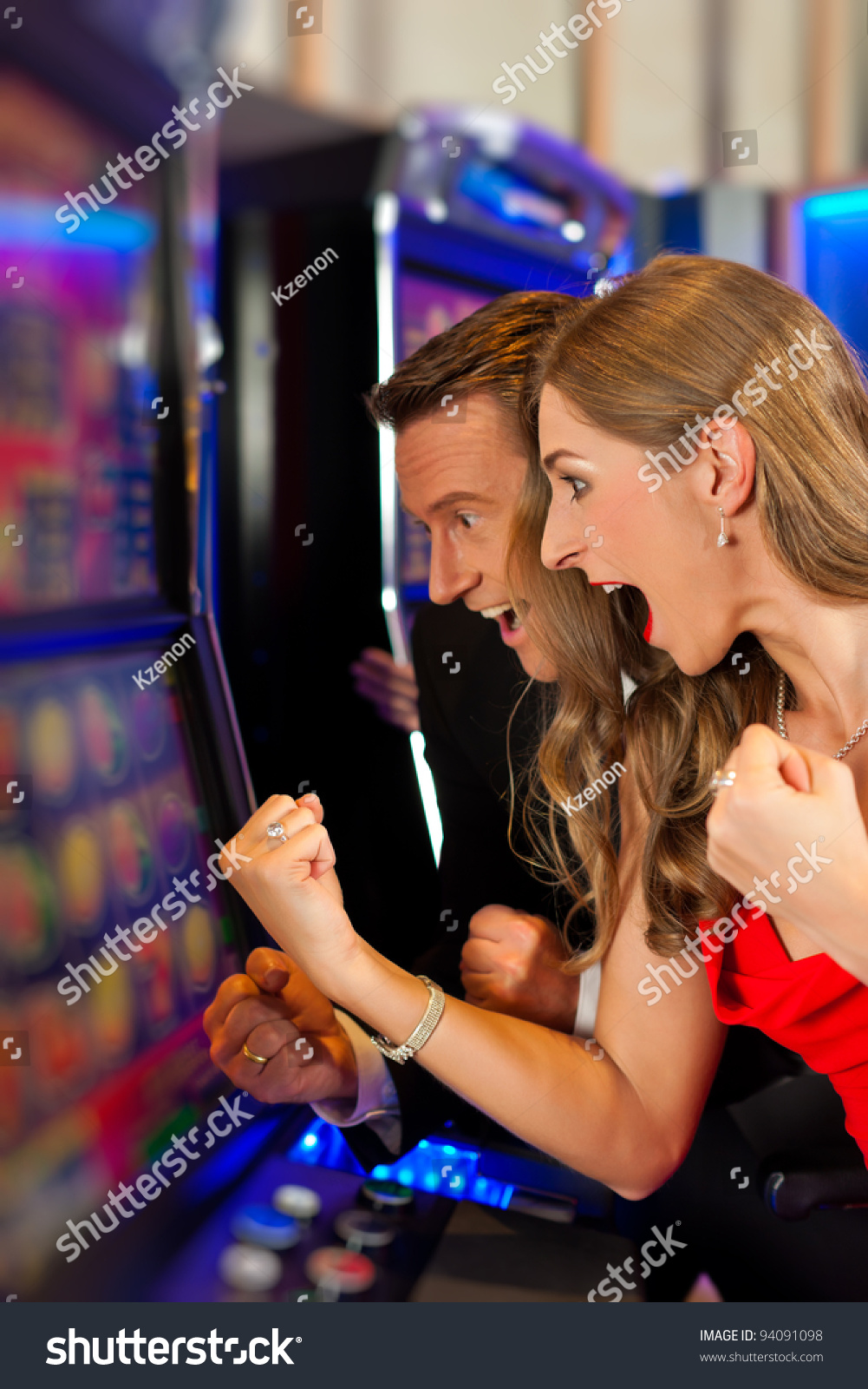 Couple in Casino on a slot machine winning and having fun #94091098